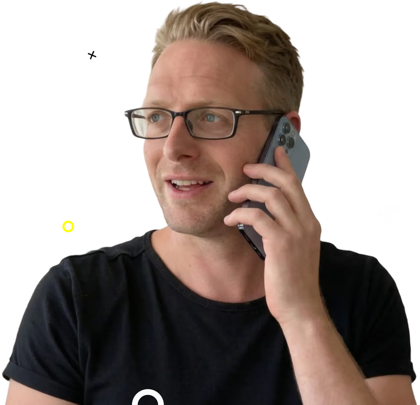 Man met blond haar en bril die met een smartphone tegen zijn oor praat, gekleed in een zwart T-shirt.