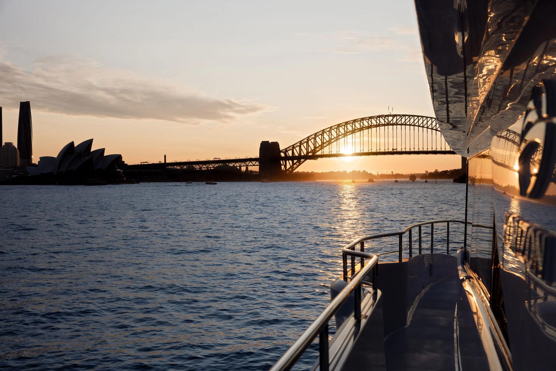 A superyacht on Sydney Harbour off the Opera House and the Harbour Bridge