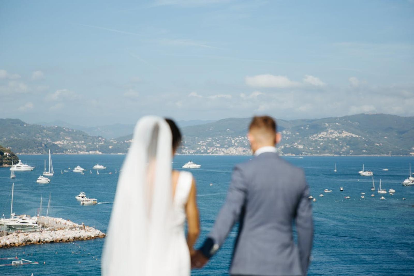 A bride and groom looking out over the water