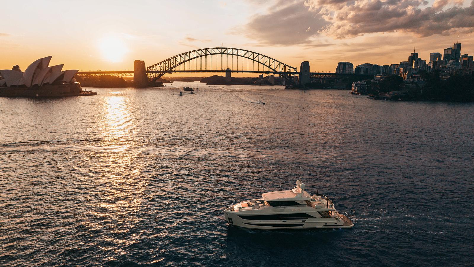 An Orraia yacht cruising Sydney Harbour at sunset