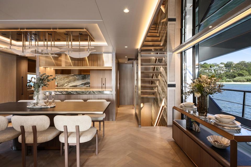Yacht dining area and staircase with harbourside view through windows