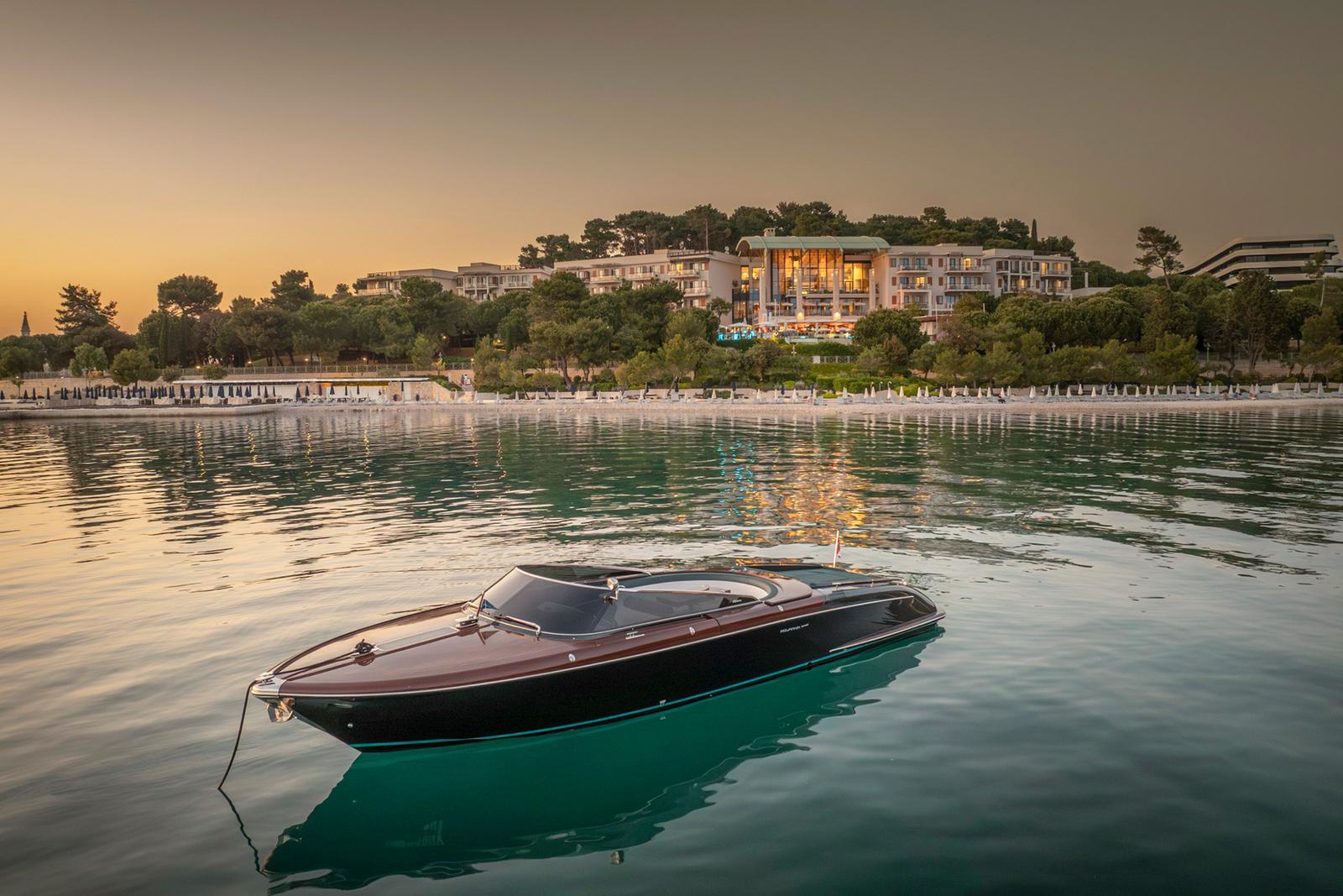An Aquariva Special at anchor below the hotel at dusk