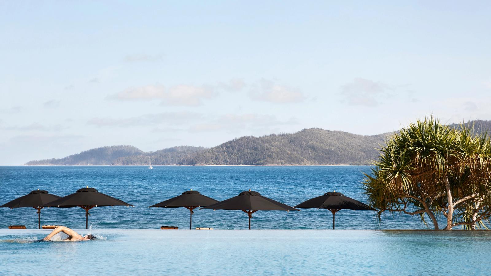 Pebble Beach — umbrellas between pool and sea
