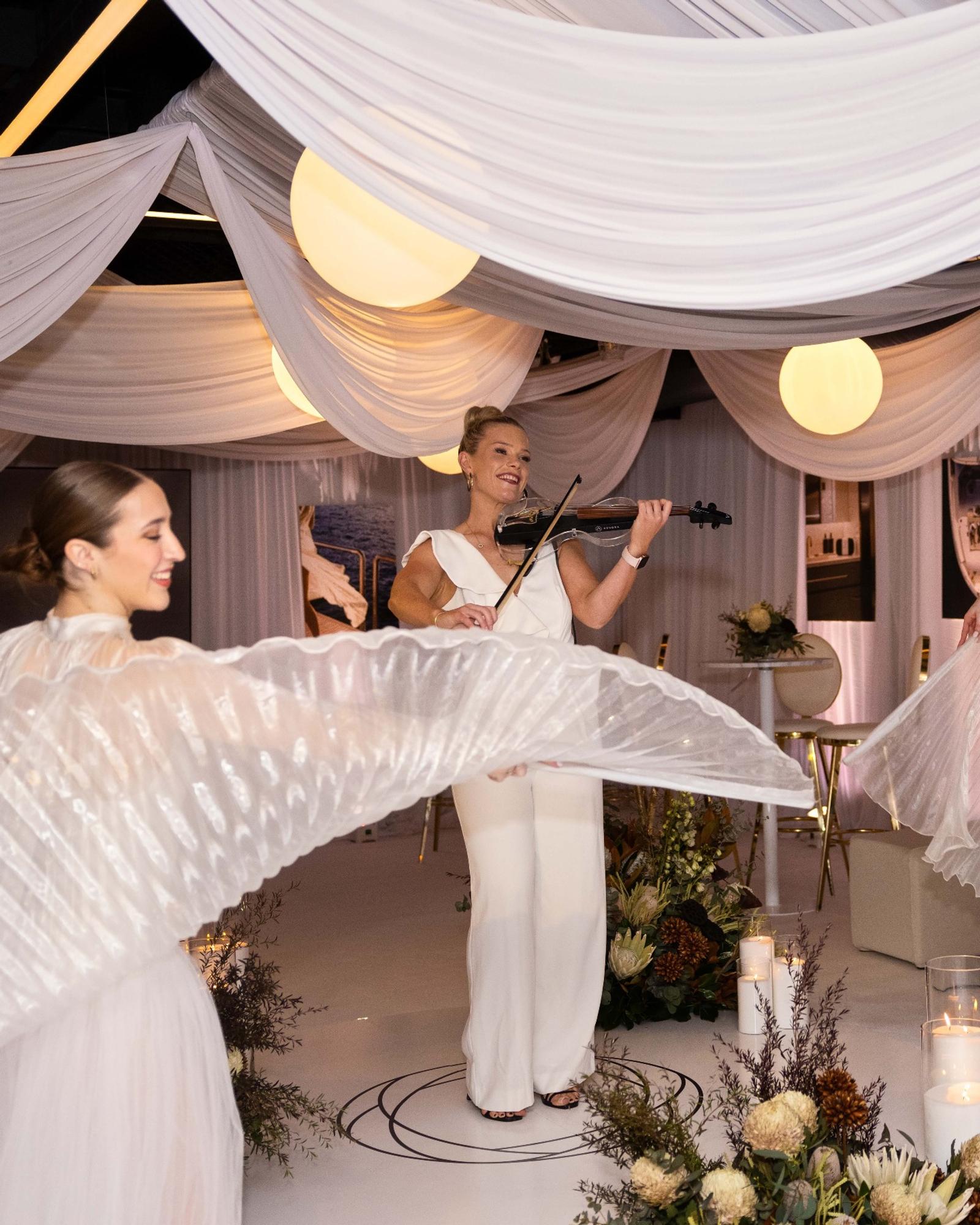 A proposal setting draped in white, a violinist playing on board