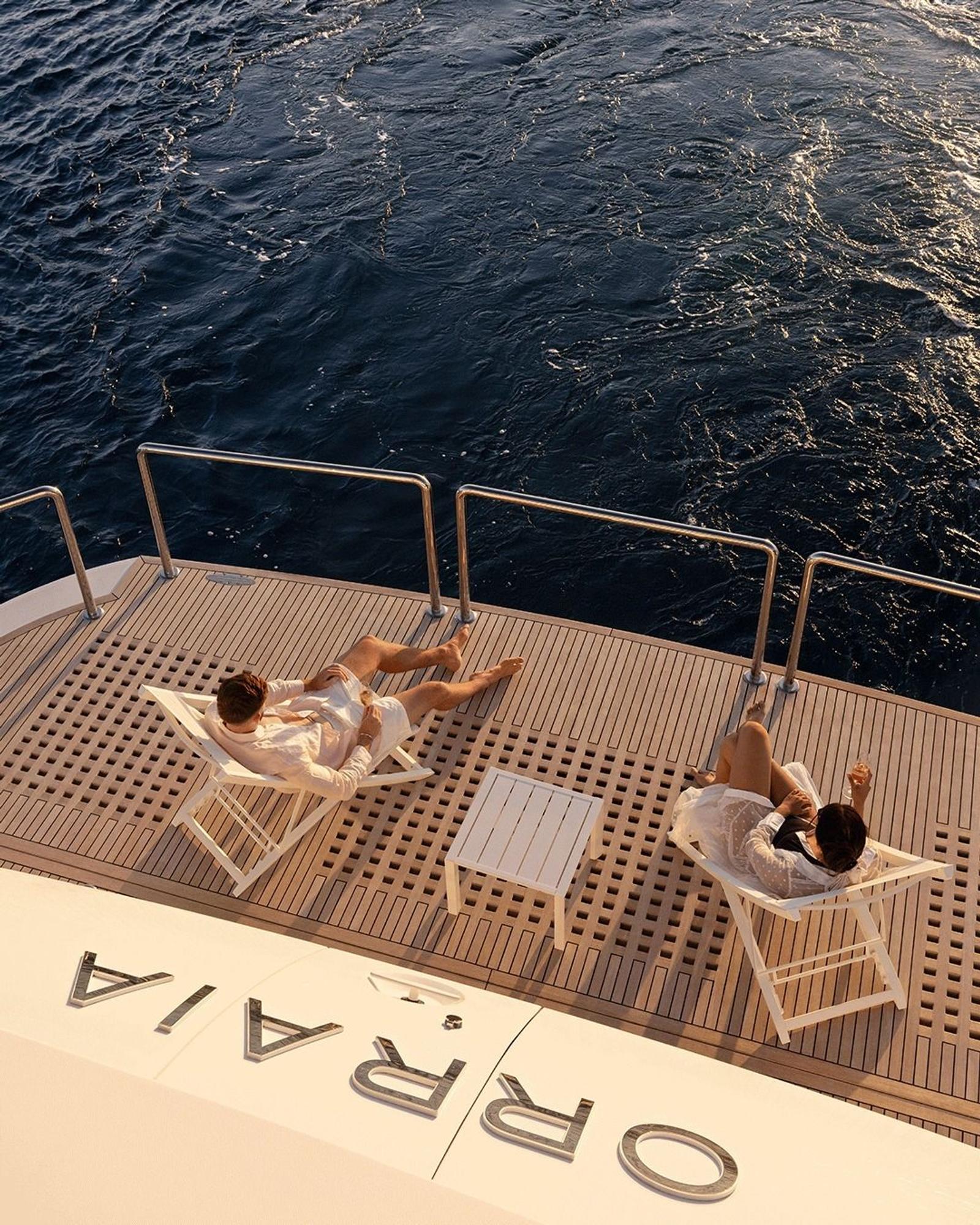 Guests on deck loungers in the late-afternoon light, from above