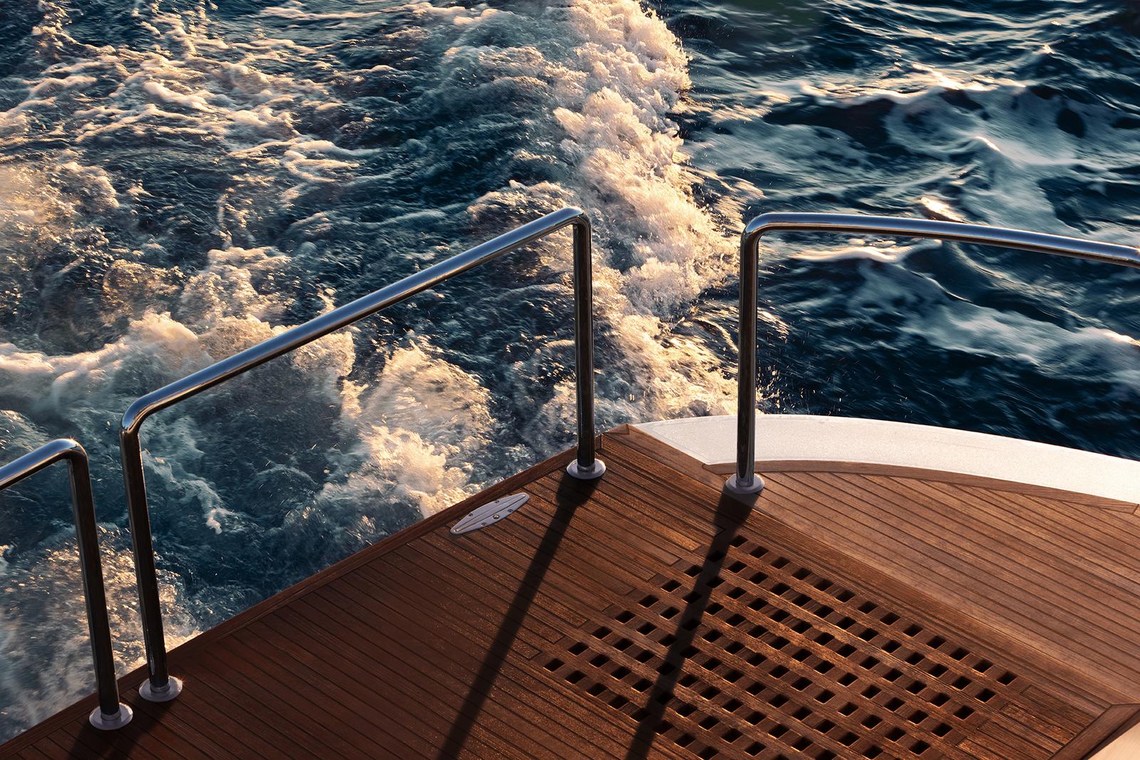 The wake running past the teak deck under way