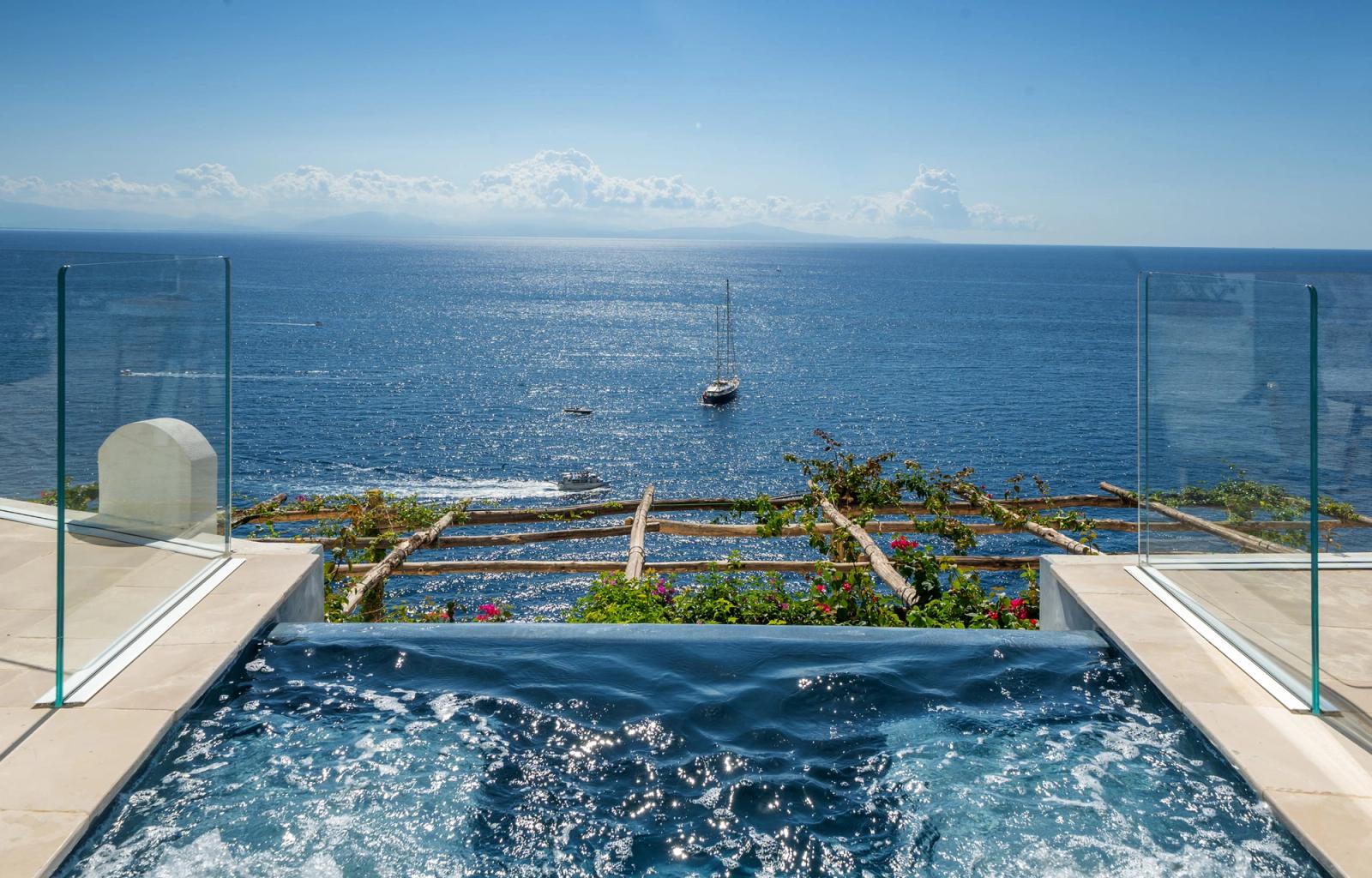 A premium pool suite opening to a terrace above the Amalfi bay