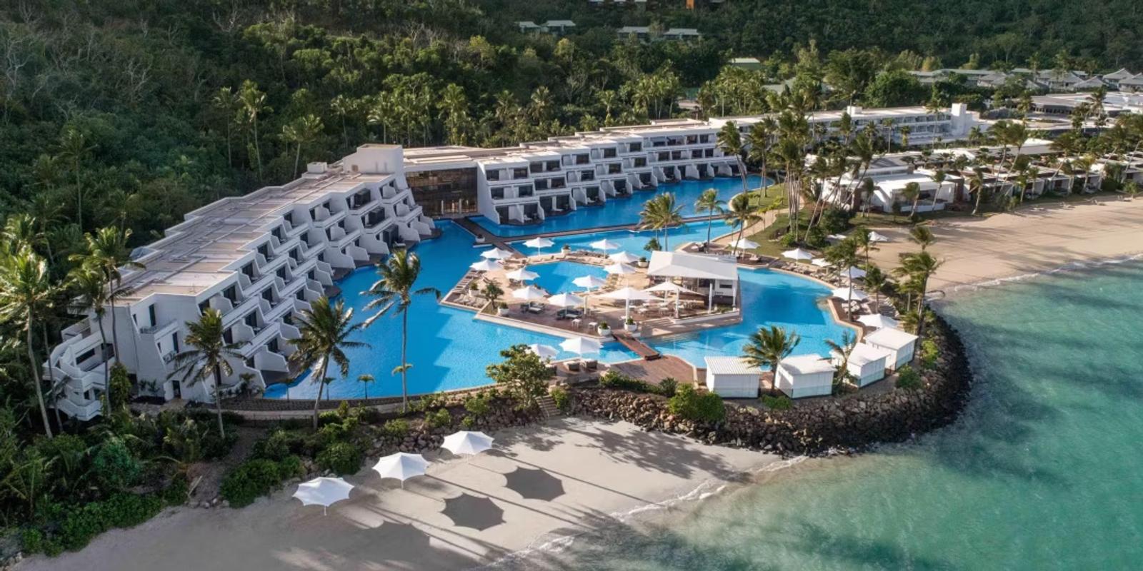 The Pool Wing wrapping Hayman Pool, beach beyond — InterContinental Hayman Island from the air