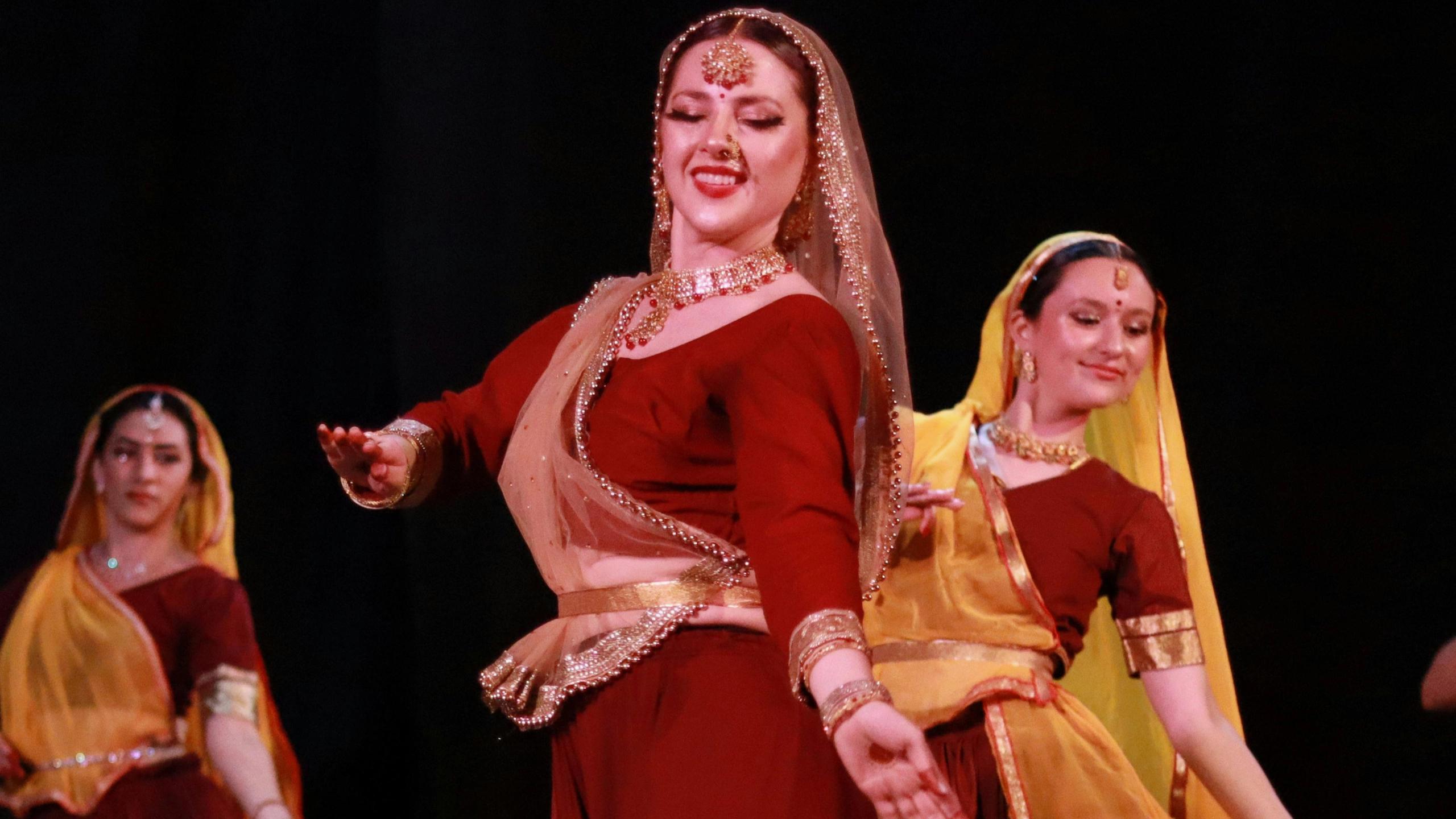 Classical Indian dancers performing on stage in traditional costume.