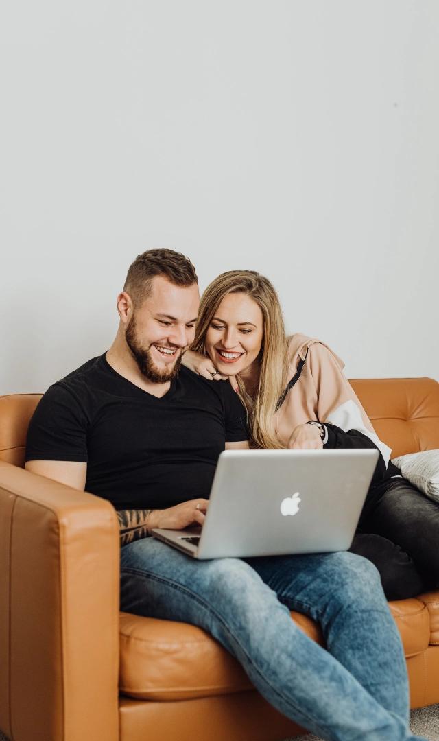 Couple smiling looking into laptop