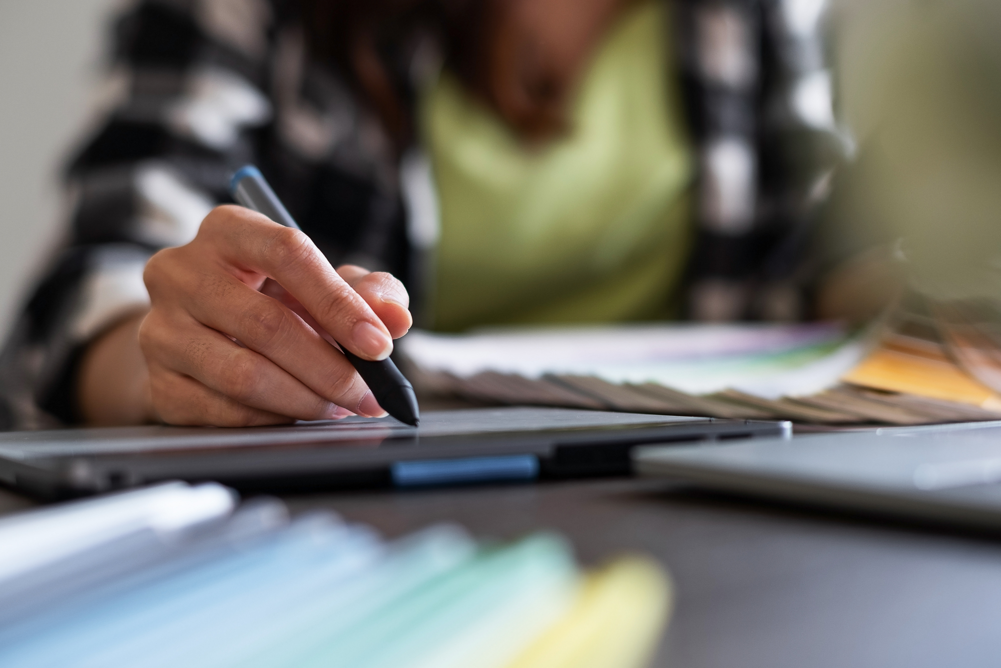 Person using a stylus on a digital tablet for design or content creation.