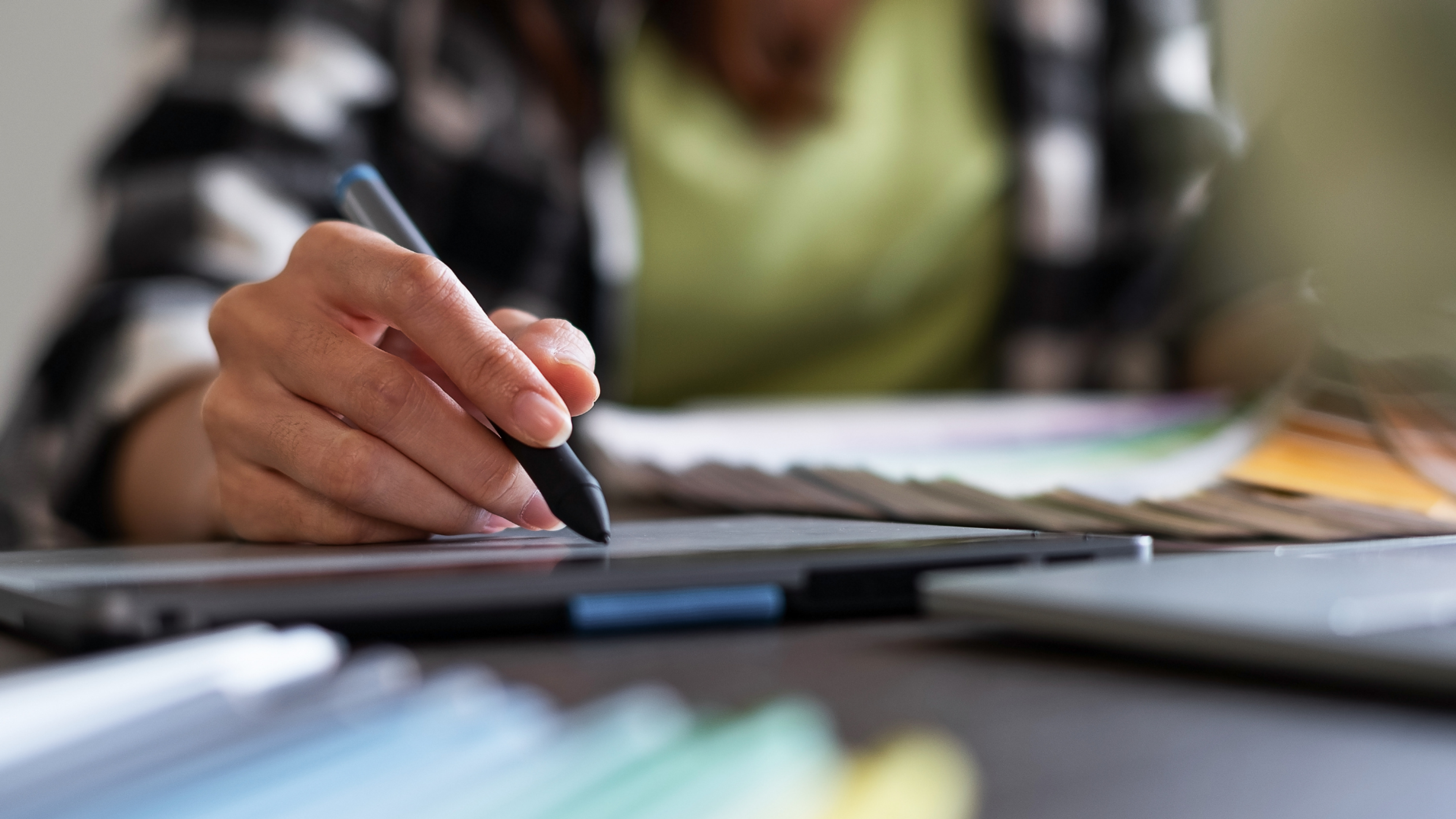 Person using a stylus on a digital tablet for design or content creation.
