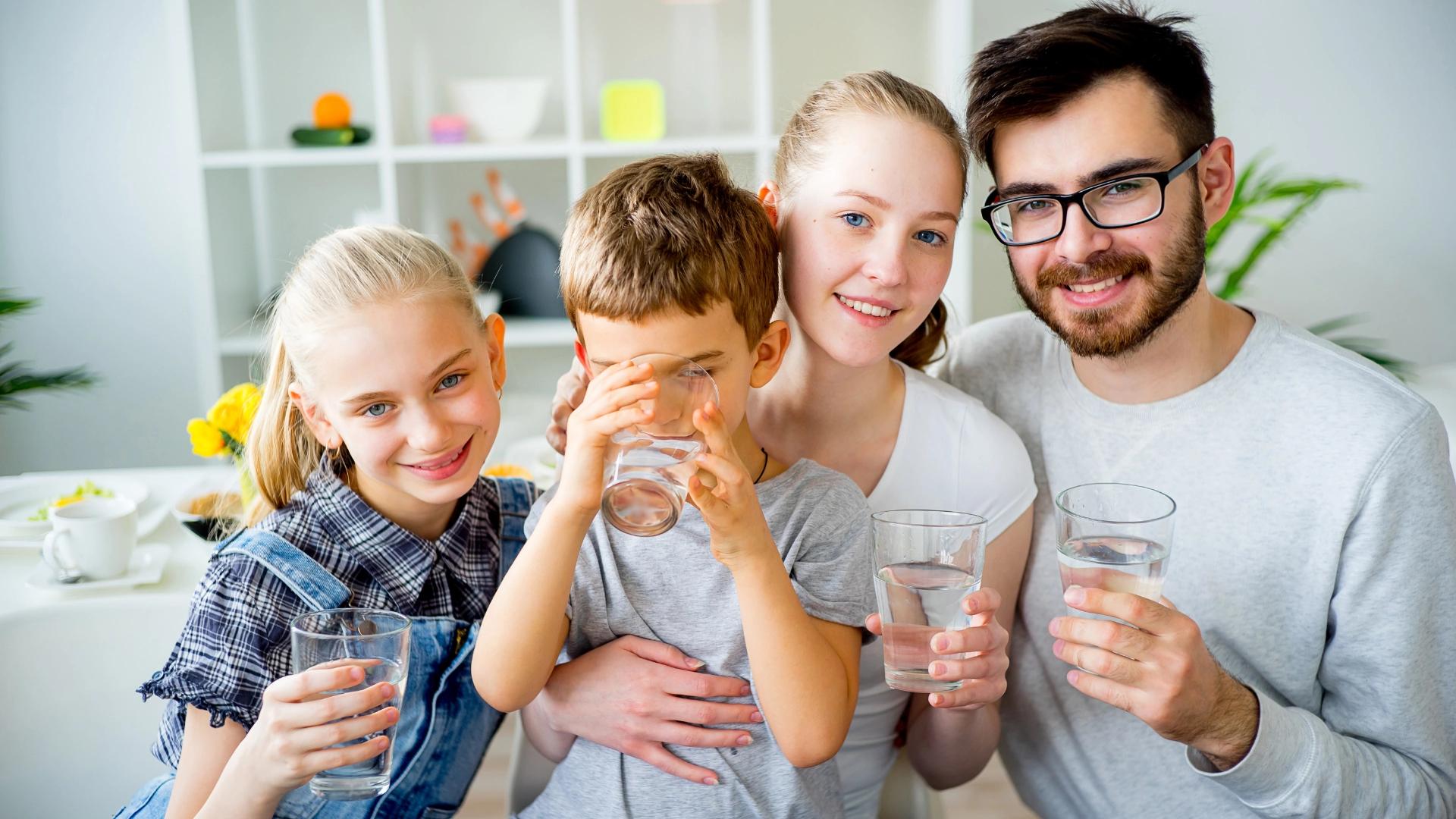 Family drinking clean filtered water from glass