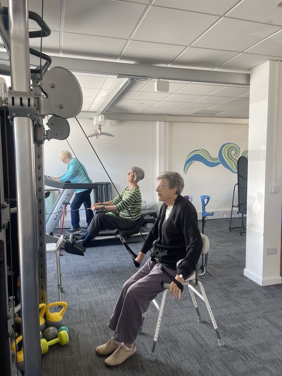 Adult group members working through seated and standing exercises during a circuit session