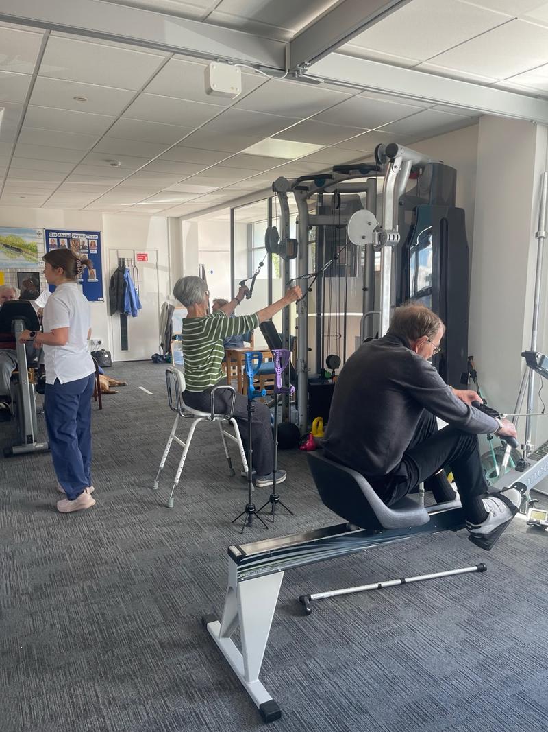 Members of the adult exercise group using the cable machine and rowing machine in the accessible gym