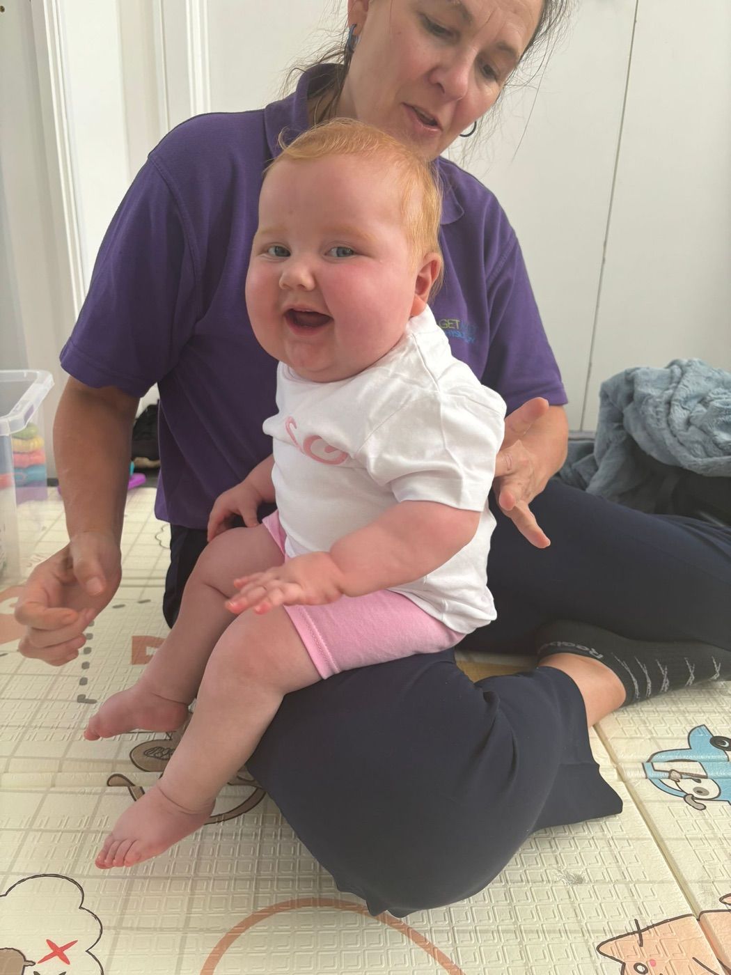 A child practising standing and balance with a physiotherapist supporting them