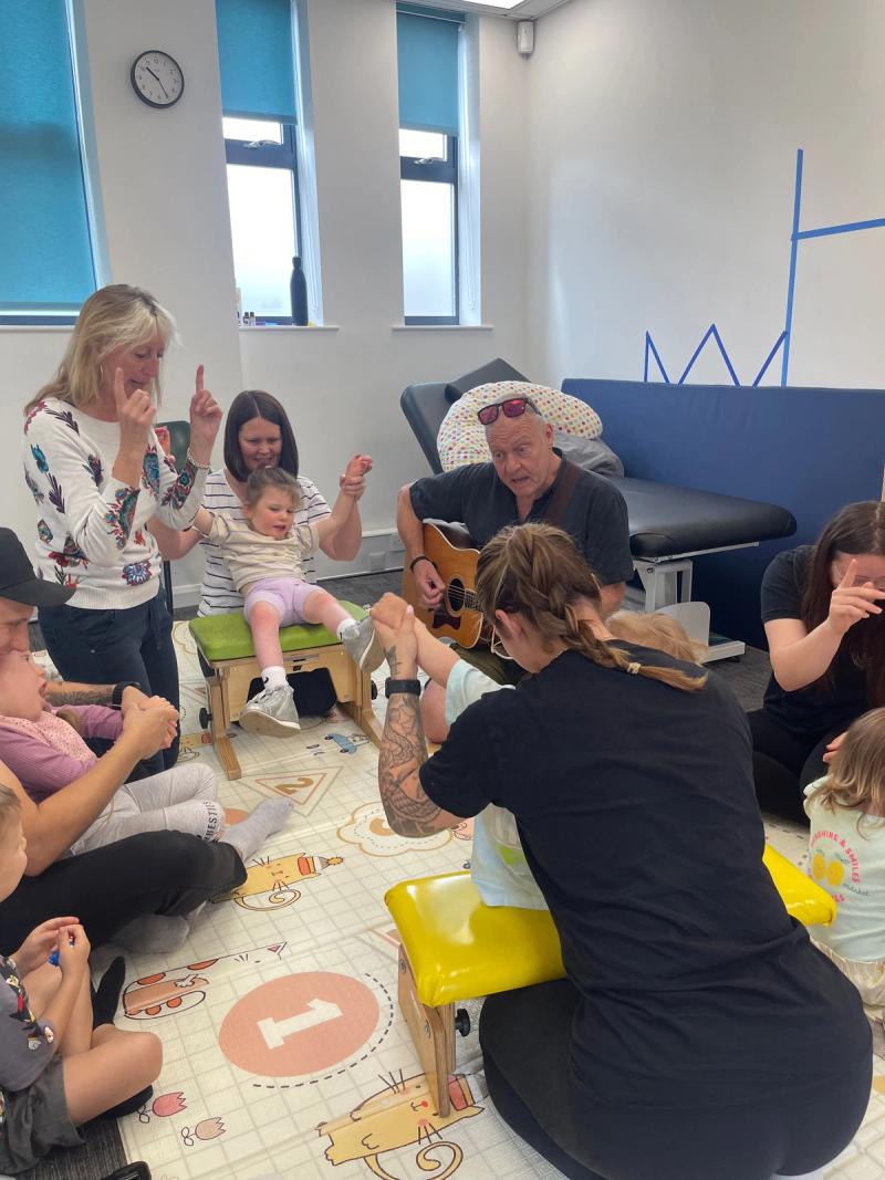 Parents and therapists singing and signing along with the group's music leader