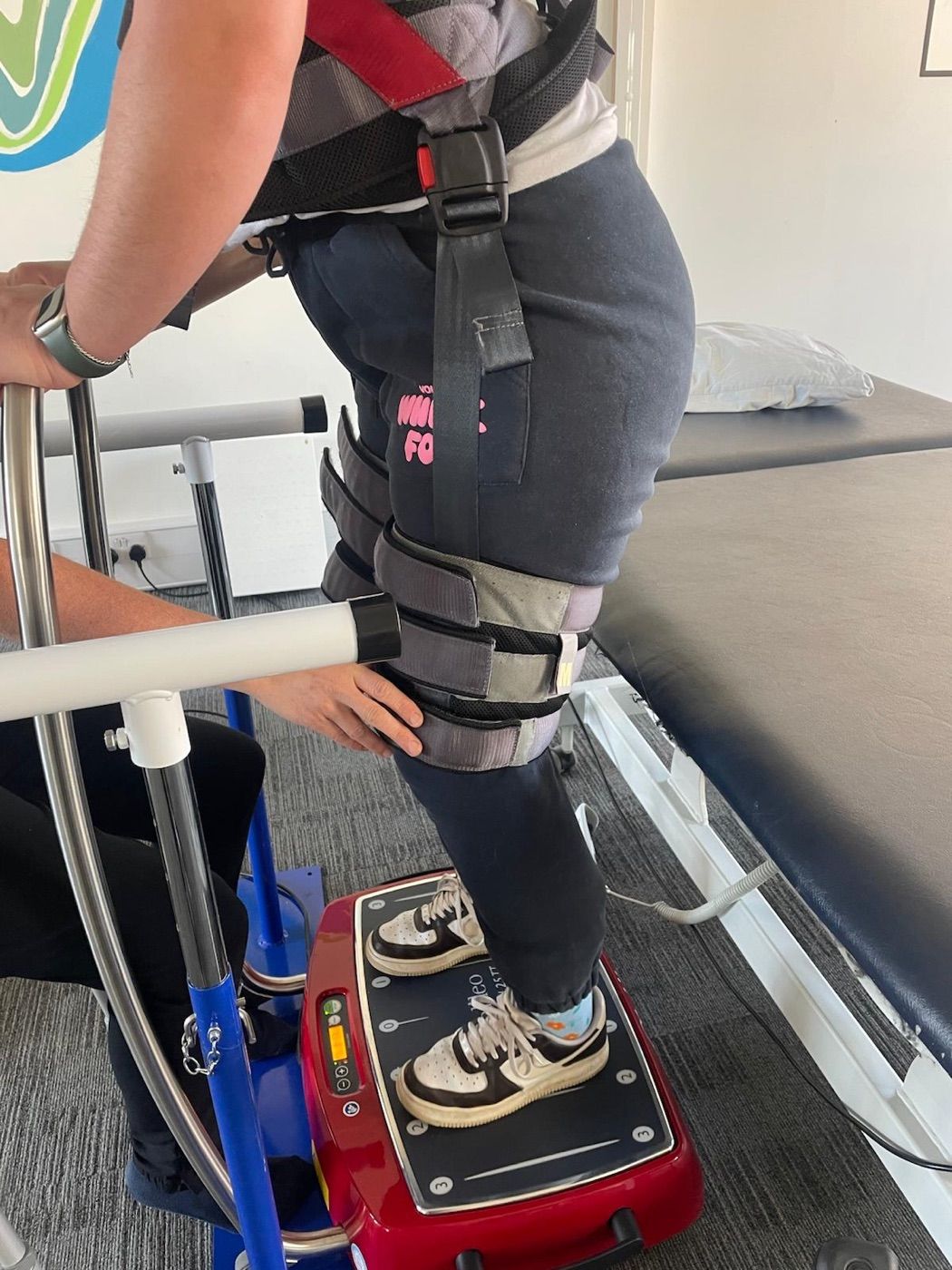 A client standing on the Galileo vibration plate in a support frame