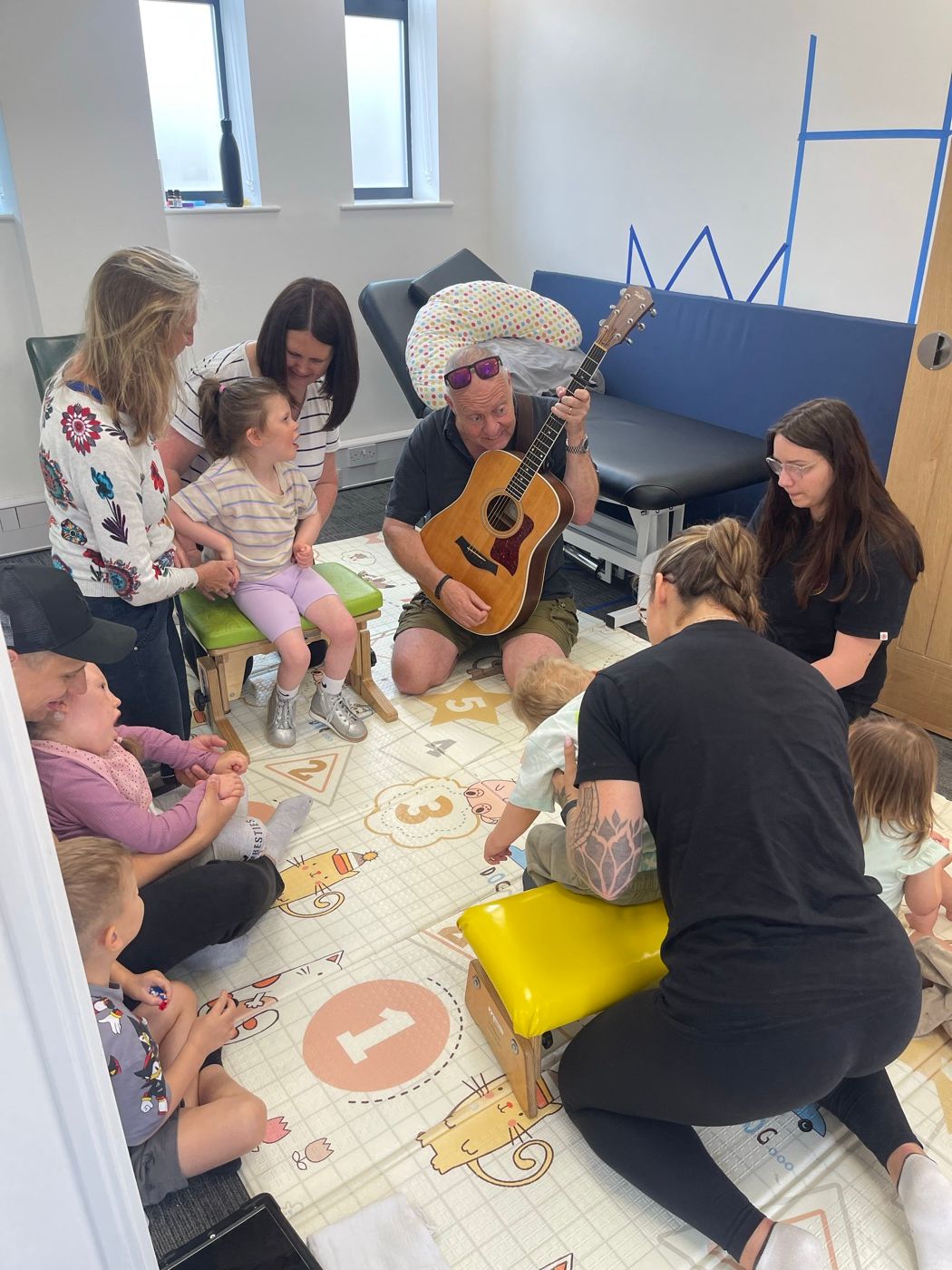 Babies and parents taking part in a music and movement group on the play mats