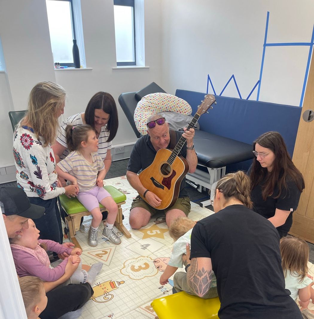 Babies and parents taking part in a music and movement group on the play mats