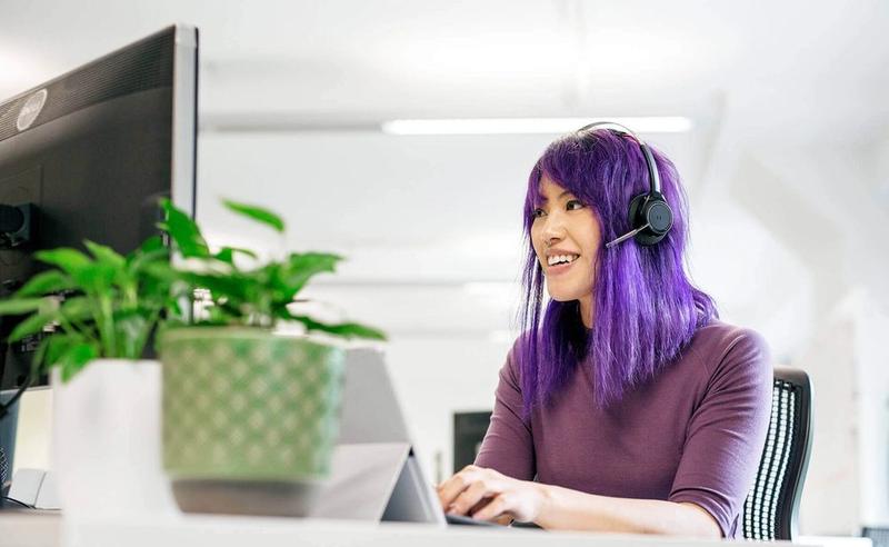 Woman with headset works in an open plan office