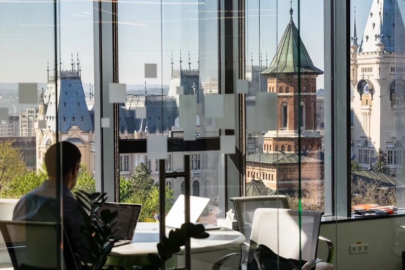 A colleague sits in a large office looking out on a picturesque skyline