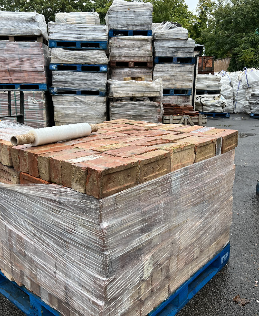 Red London bricks stacked on blue pallet