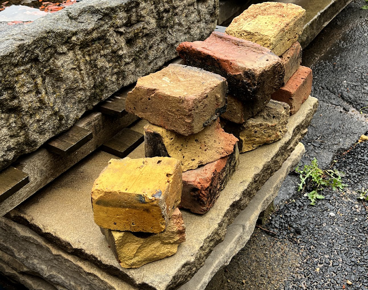 Pile of broken red and yellow London bricks on paving slab