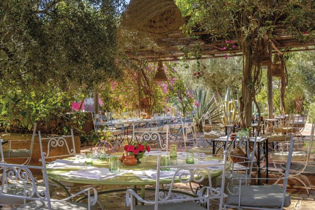 Beldi Country Club glasshouse ceremony venue surrounded by tropical palms, Marrakech