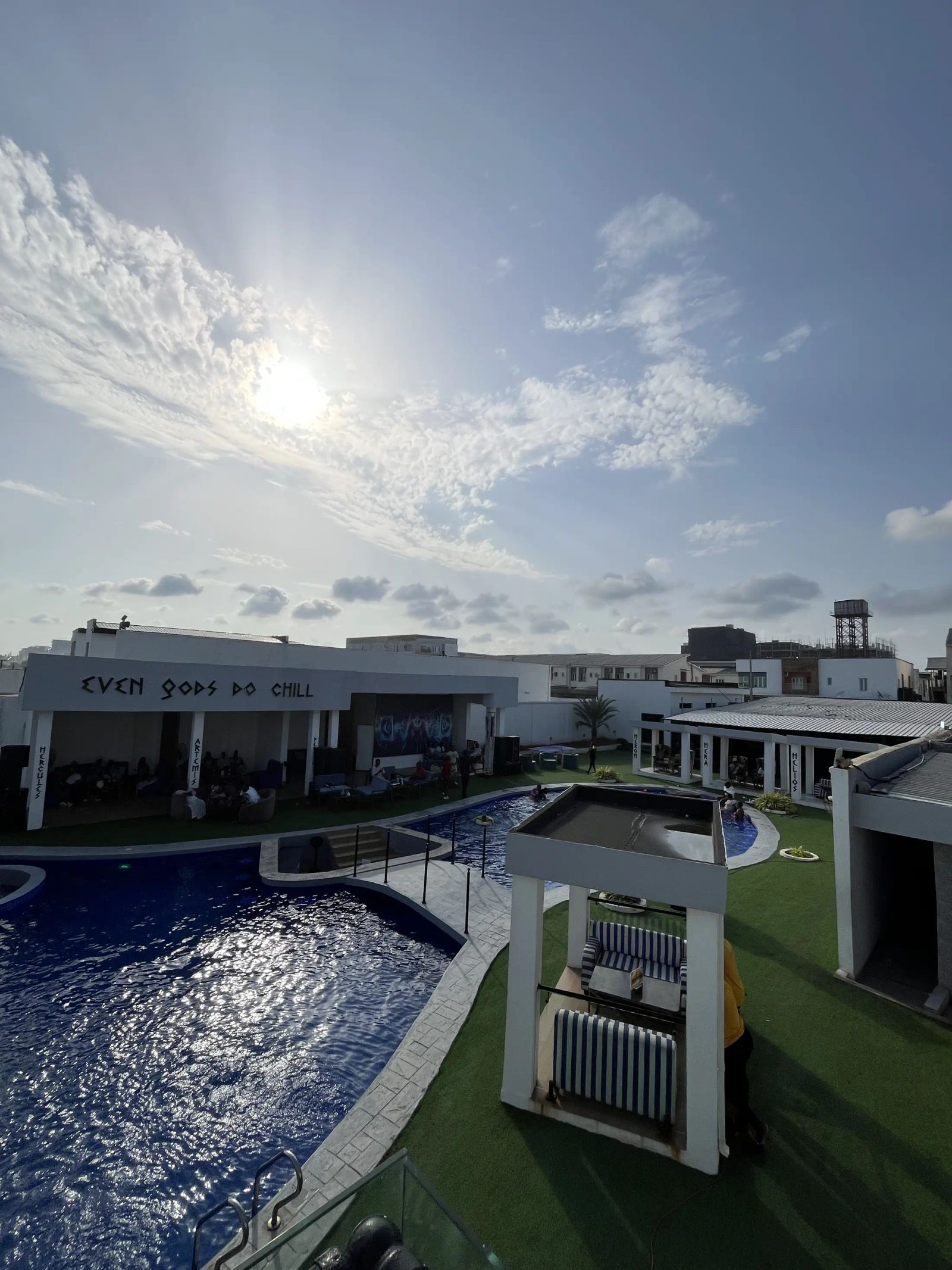 The sun high over the lagoon pool and the cabanas