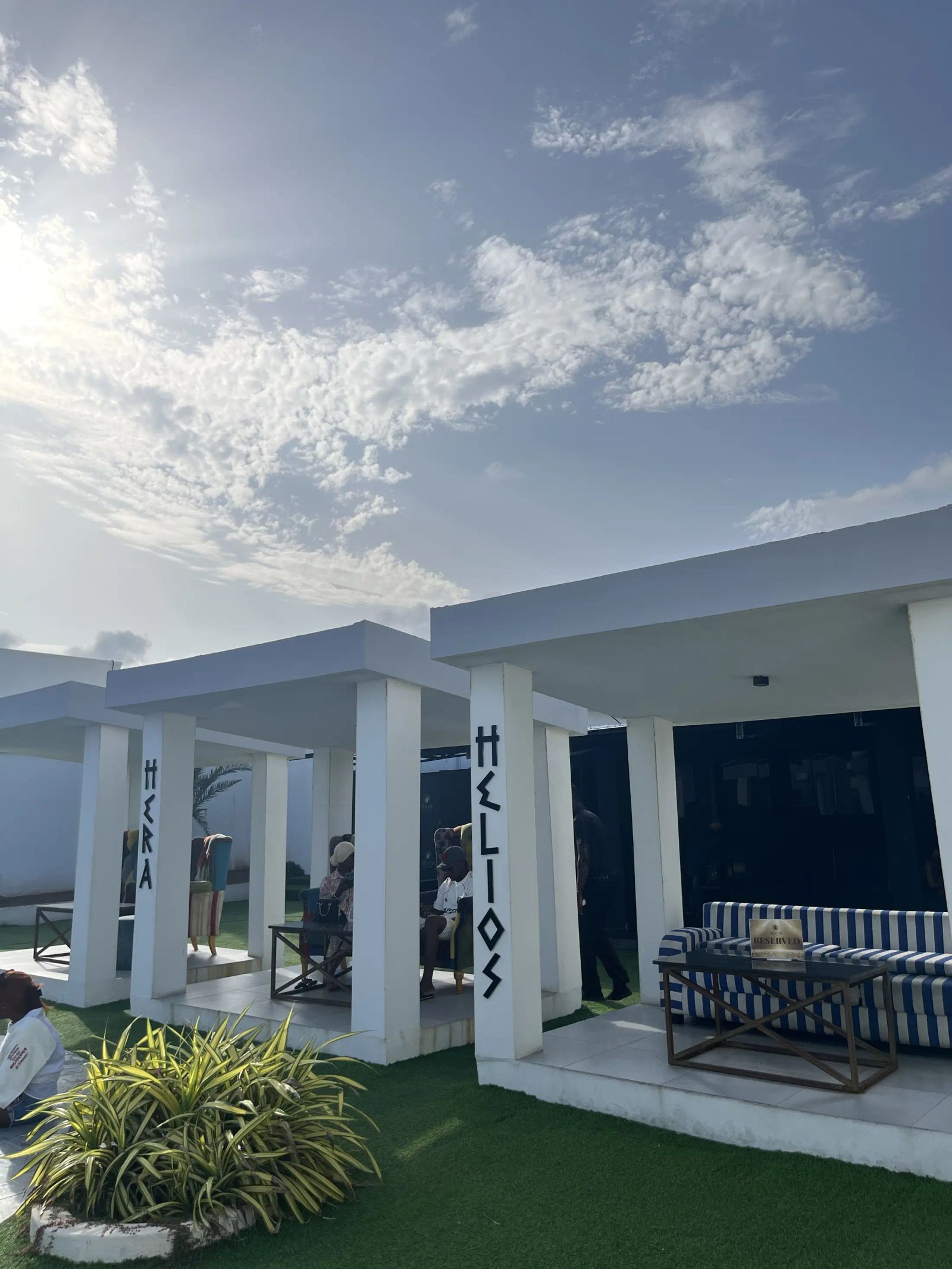 White cabanas with striped seating by the pool