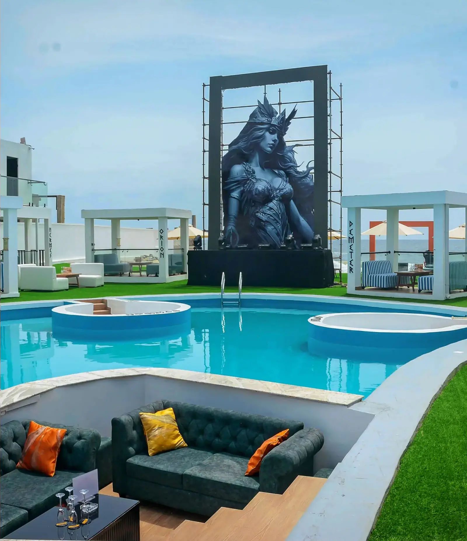 The Athena statue in its frame at the head of the lagoon pool, a sunken lounge in front
