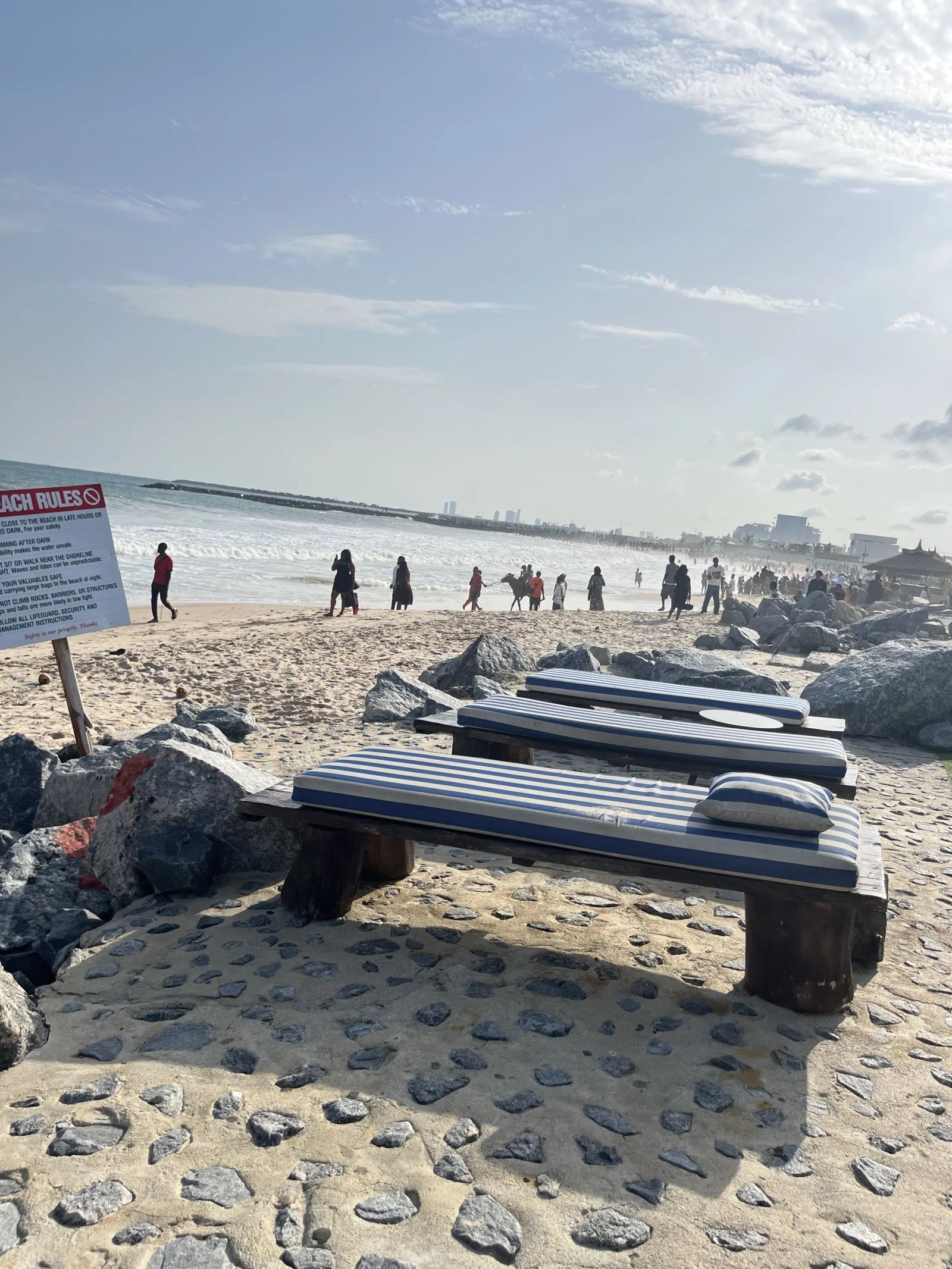 Loungers on the beach, people at the water's edge