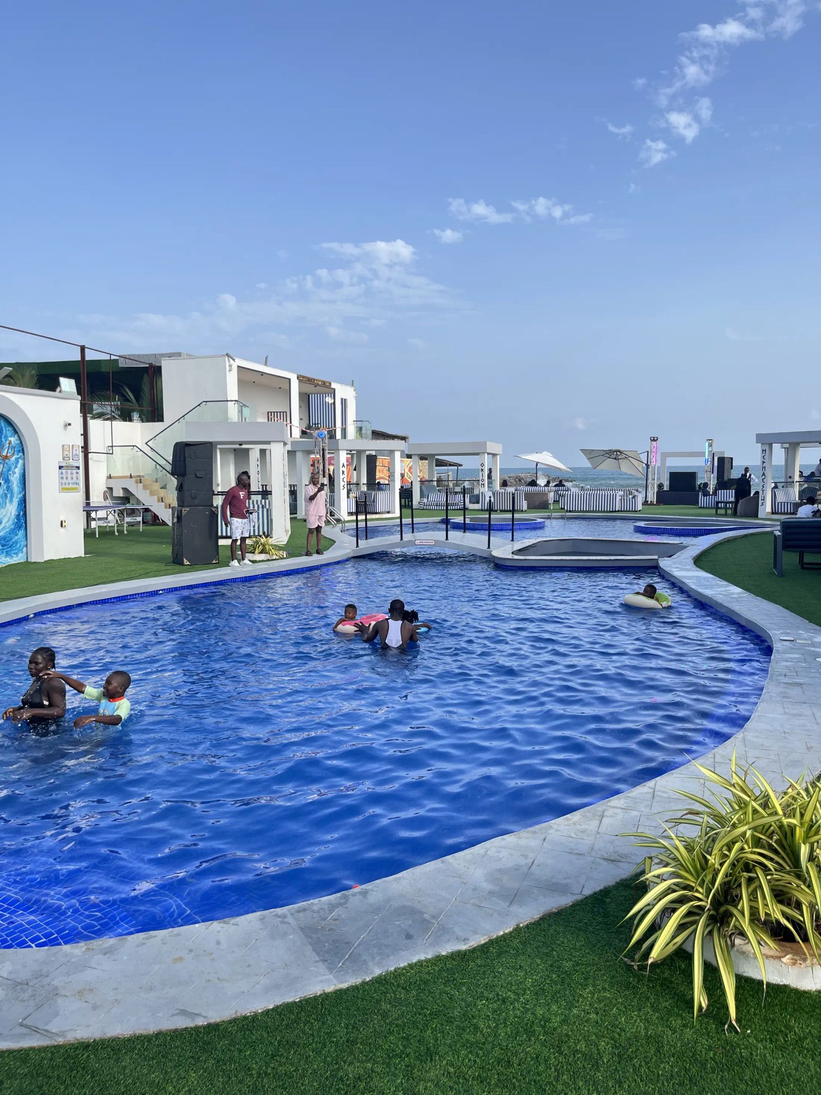 The lagoon pool with swimmers under a blue sky