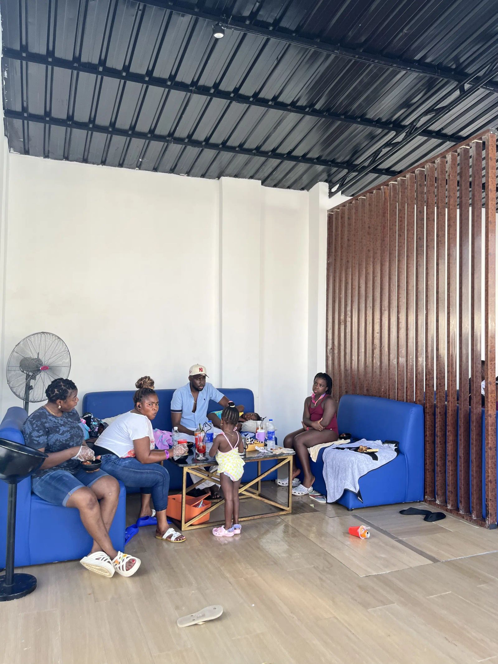 Guests relaxing on blue sofas in the shade