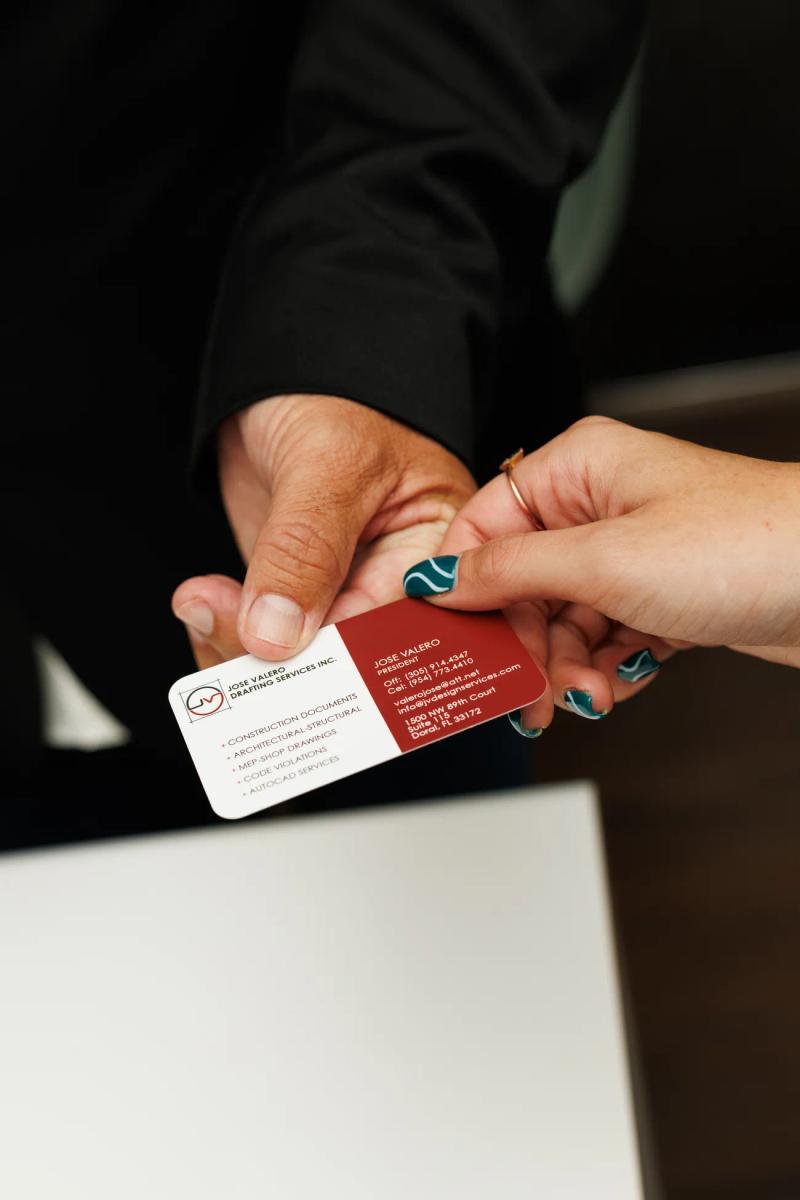 A JV Design Services business card handed over at the office