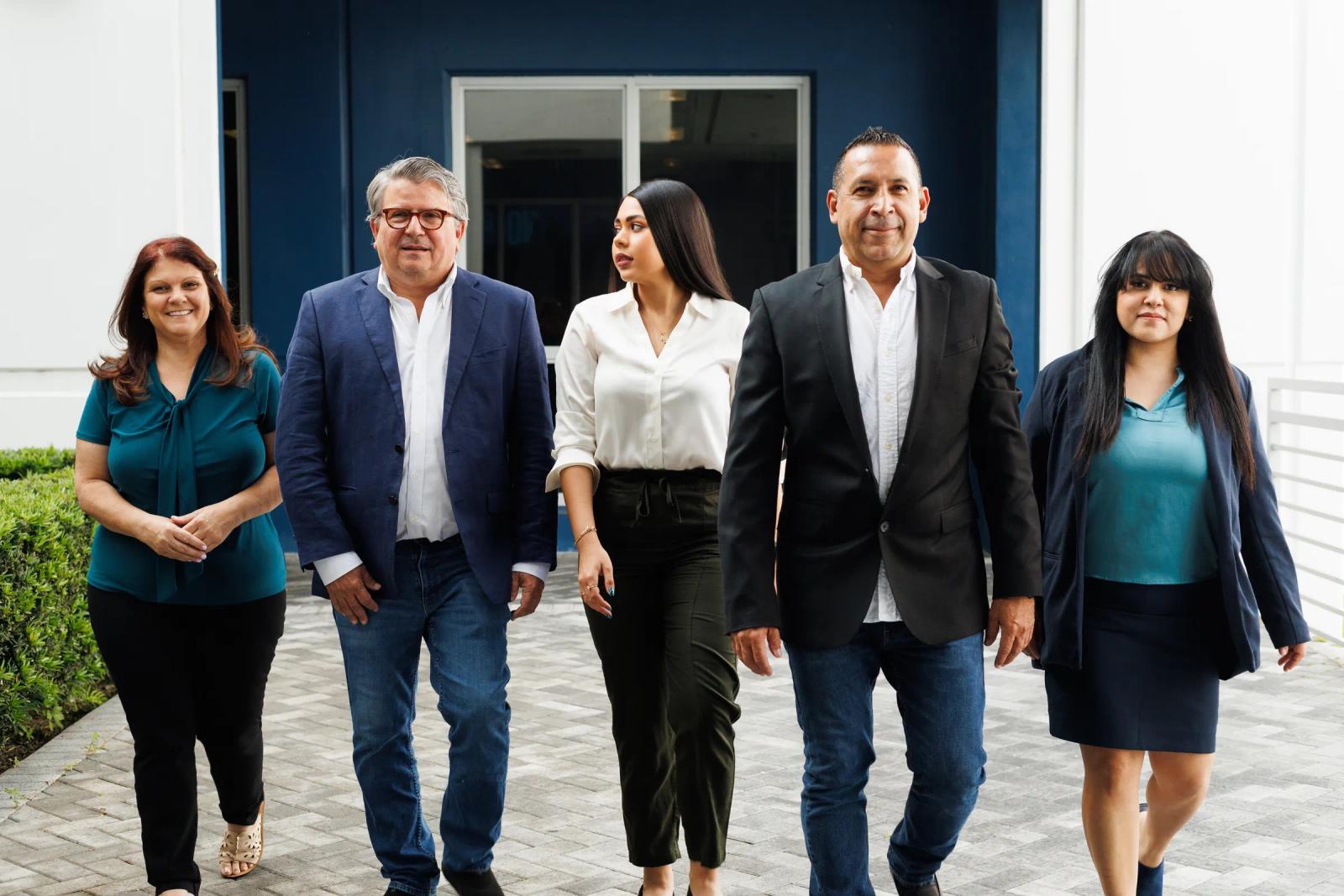 The JV Design Services team at the entrance of their Doral office