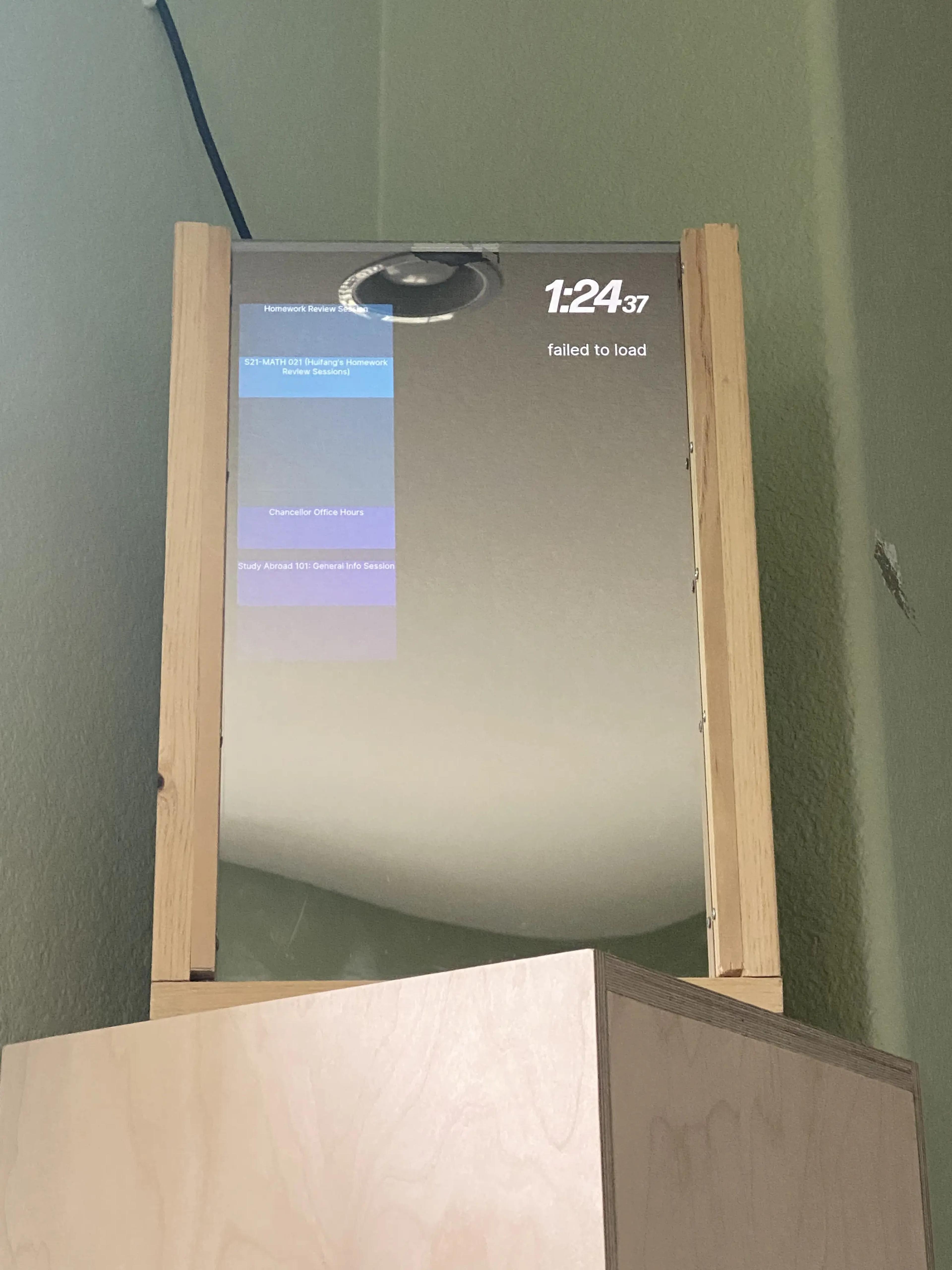 My Magic Mirror running the app I made. There are a few blocks signifying upcoming events placed on a vertical timeline. There is a clock on the top right corner, and beneath it, there's text that says "failed to load".