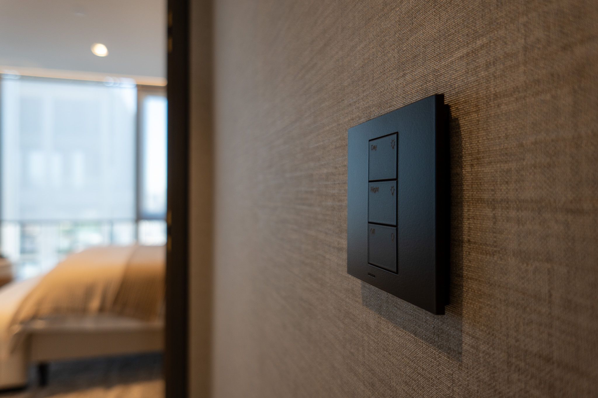 Wall-mounted keypad for day, night and off lighting scenes beside a bedroom