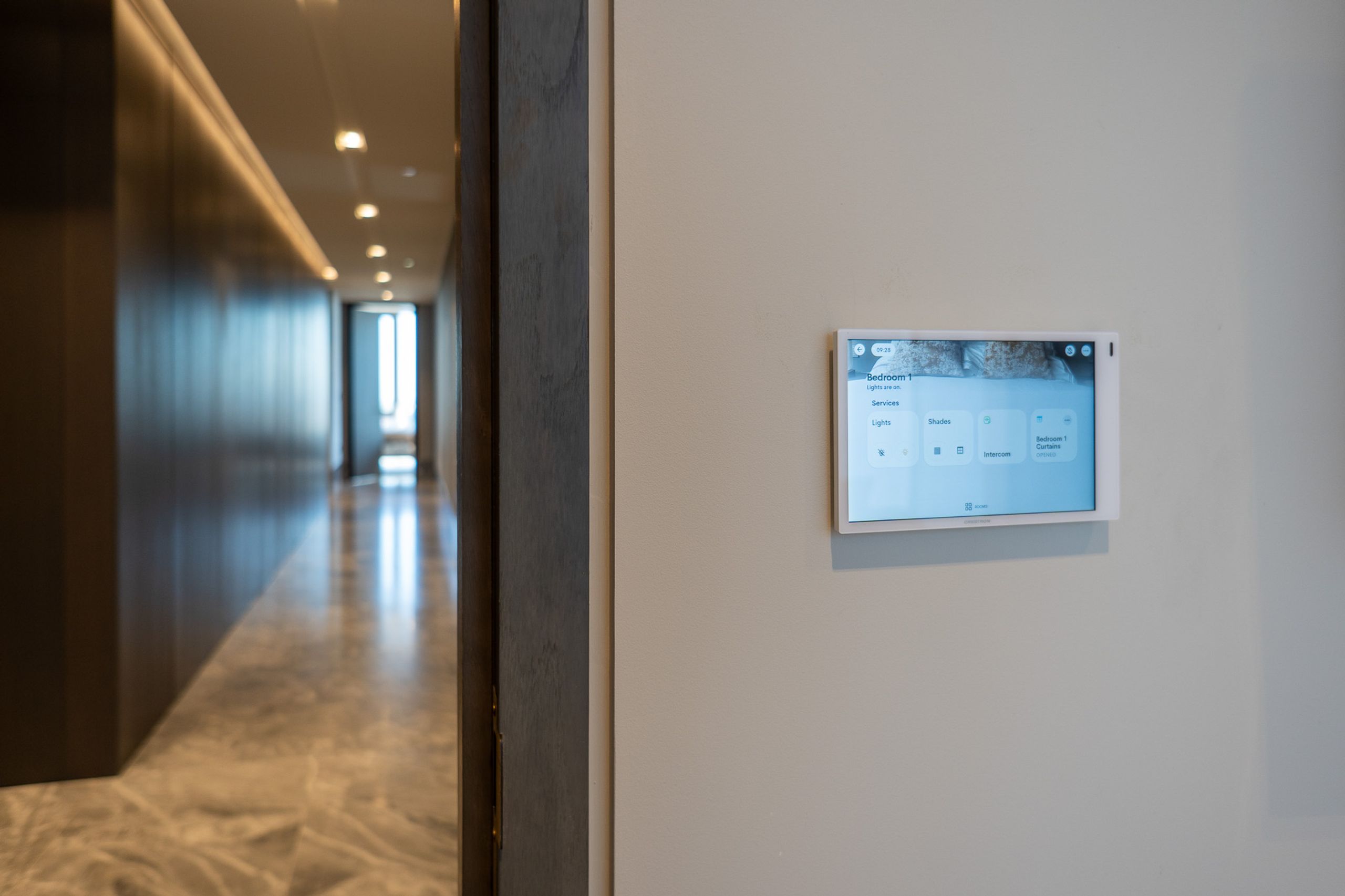 Wall-mounted Crestron Home touchscreen in the South Bank penthouse corridor