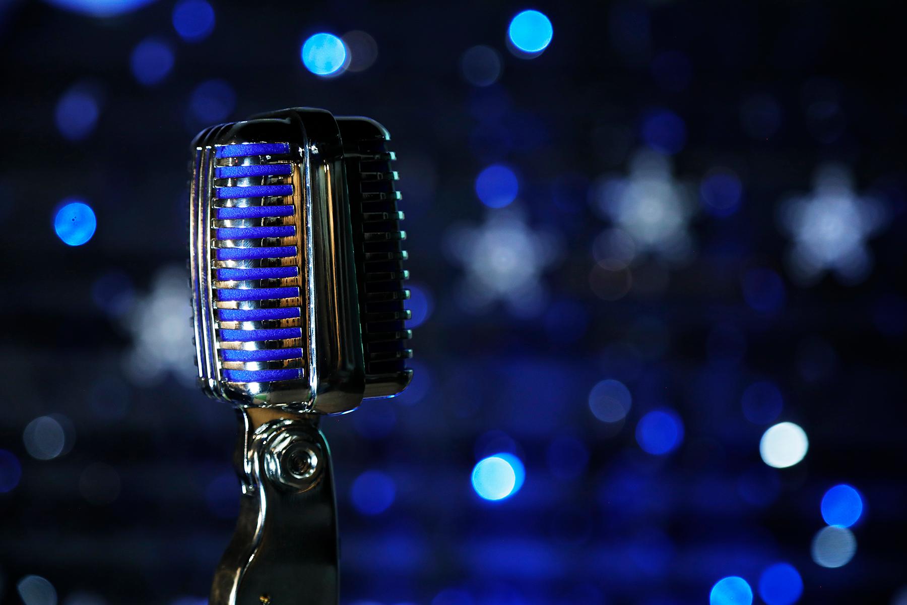 Microphone close up with sparkly blue background.