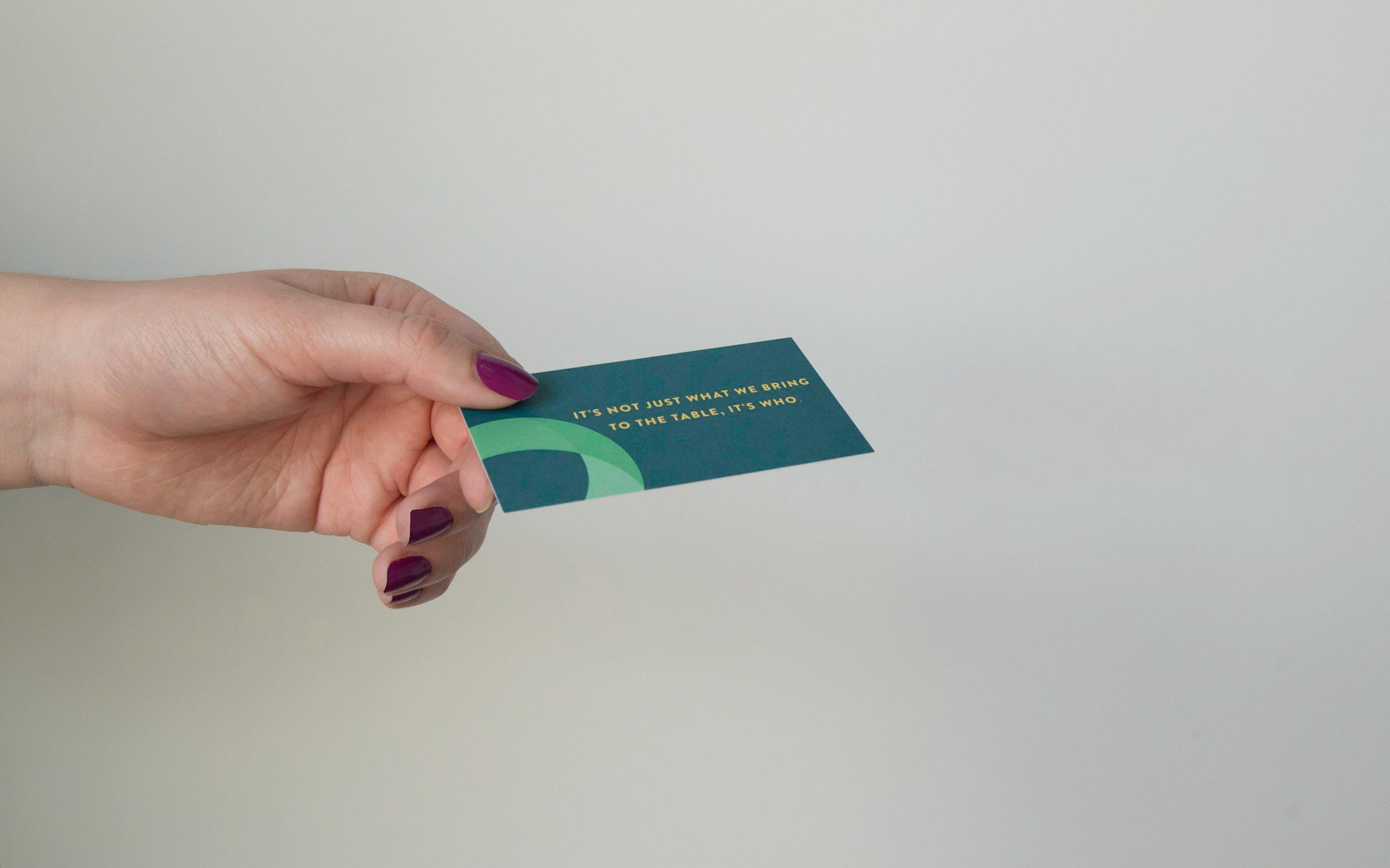 Person holding printed Oasis business card.