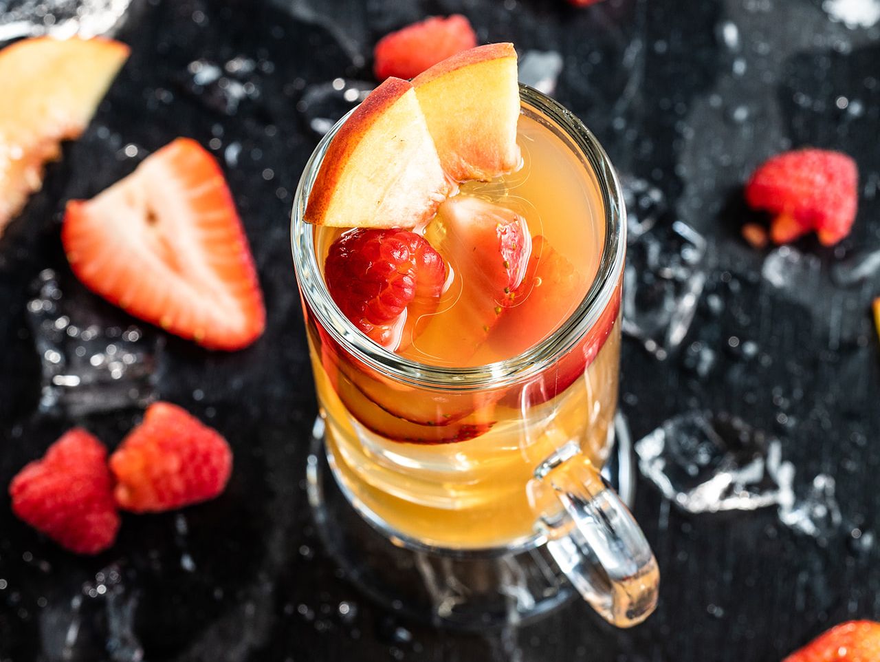 Strawberry peach beverage in a clear mug.