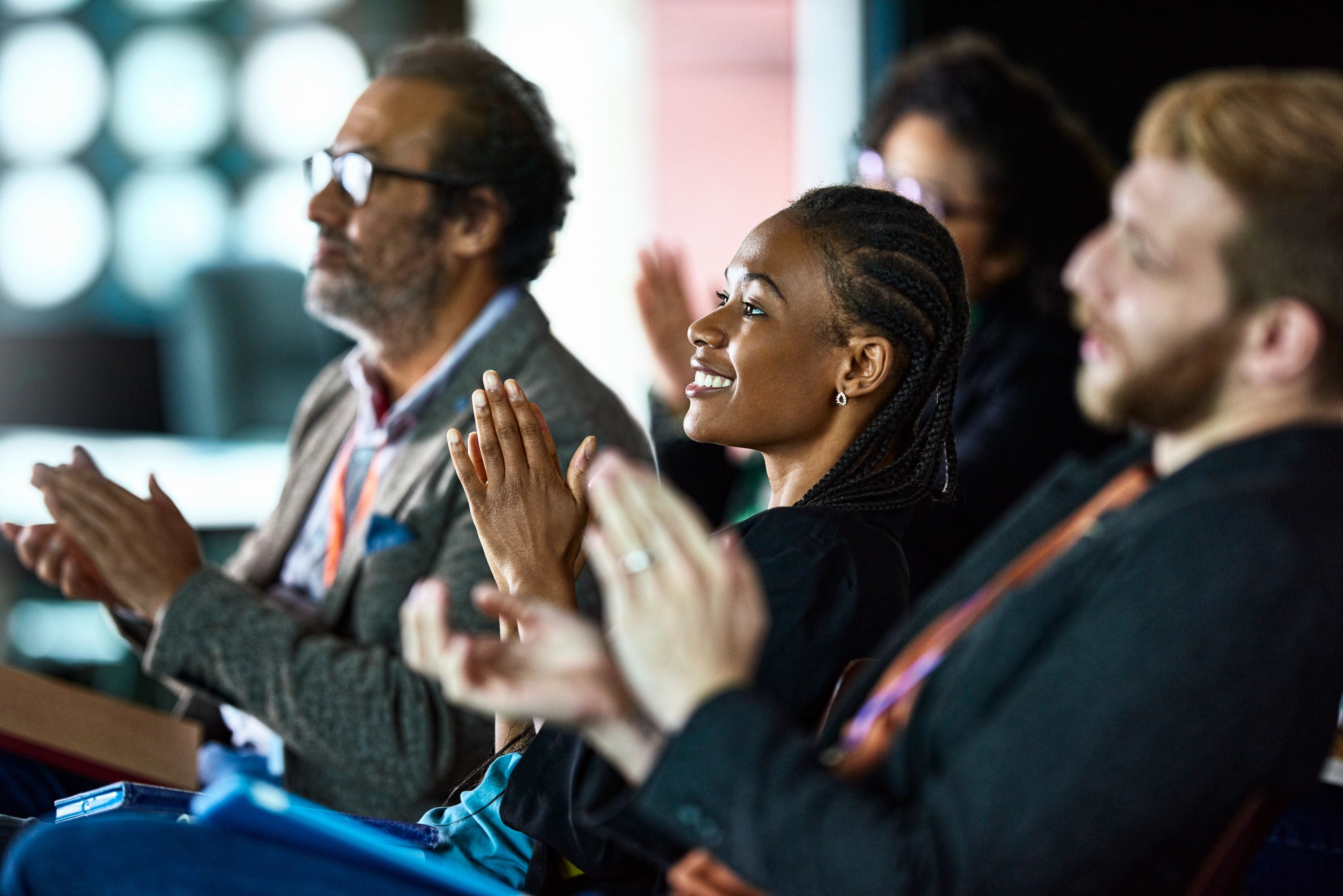 Business professionals applauding at a conference.