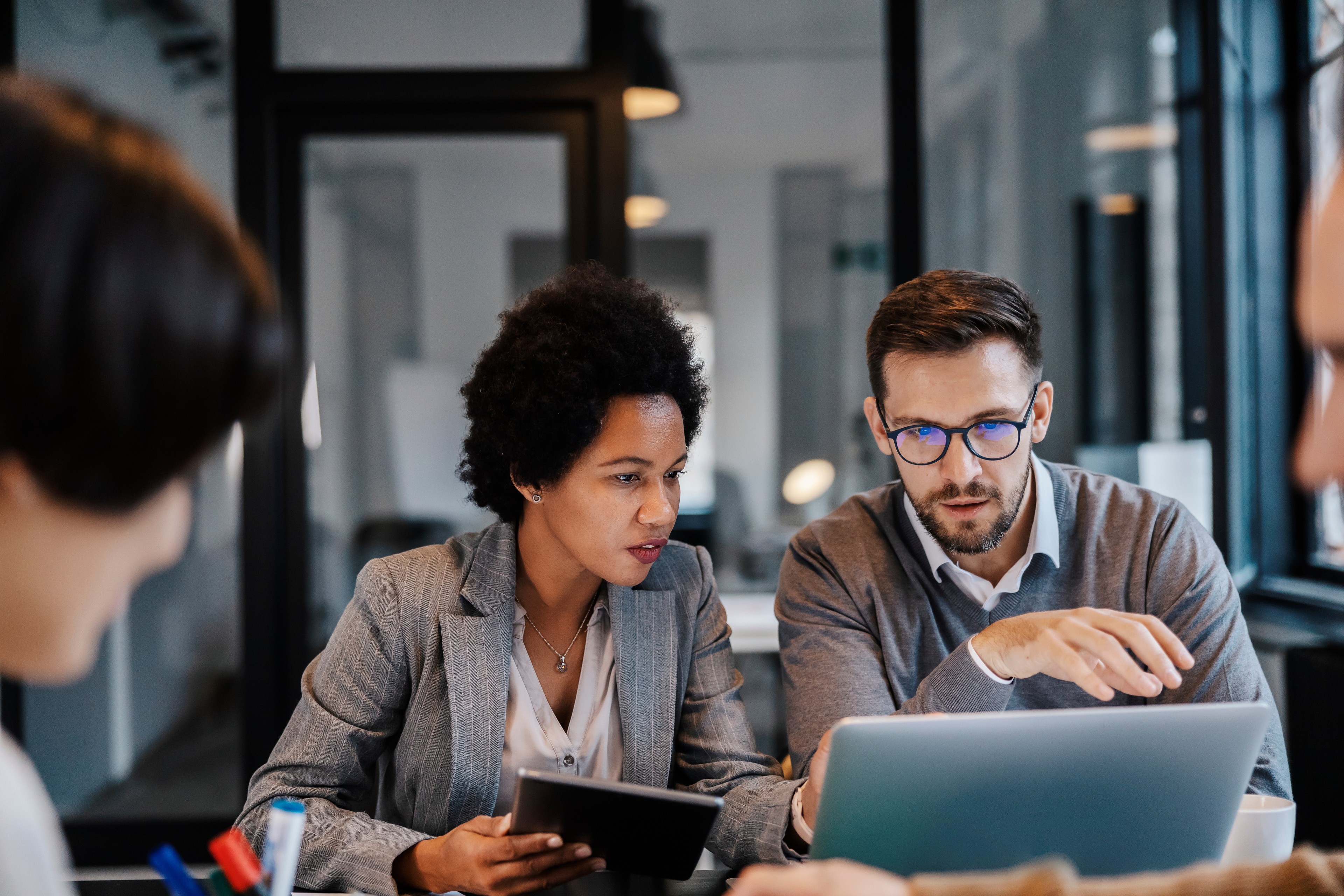 two collegues discussing some thing on laptop screen