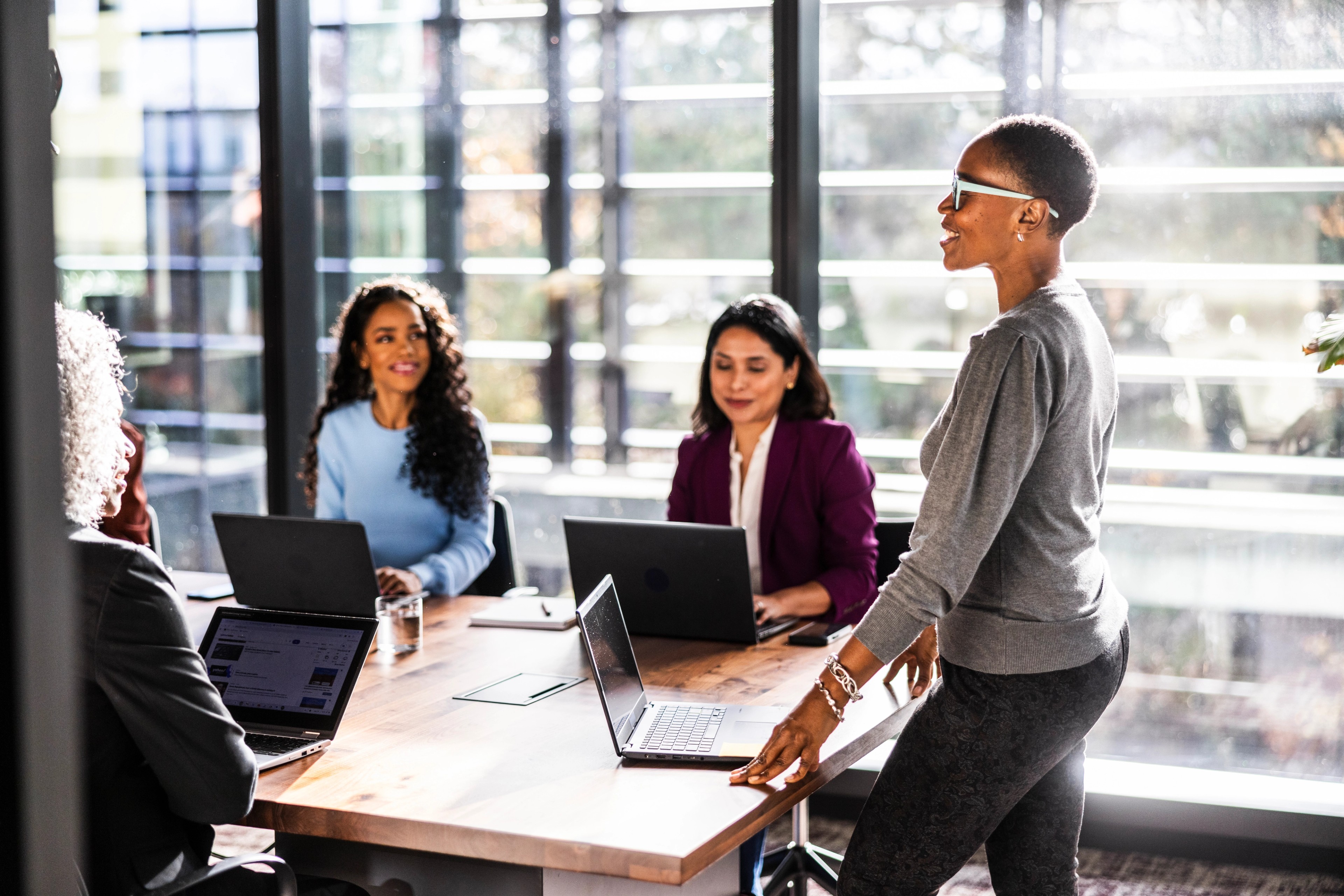 Female business owner speaking to office workers in modern conference room