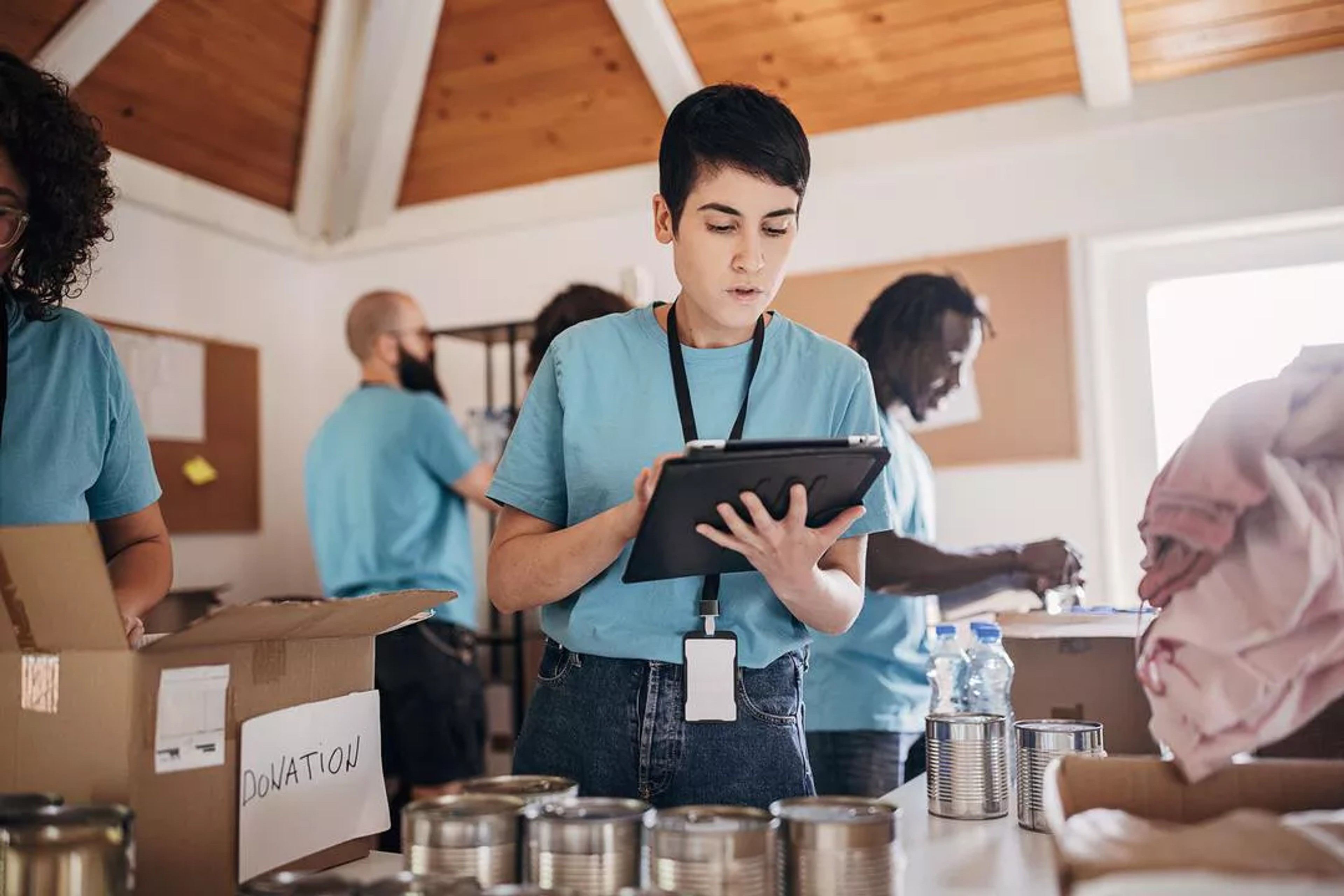 Group of volunteers gather donations and track items on ipads