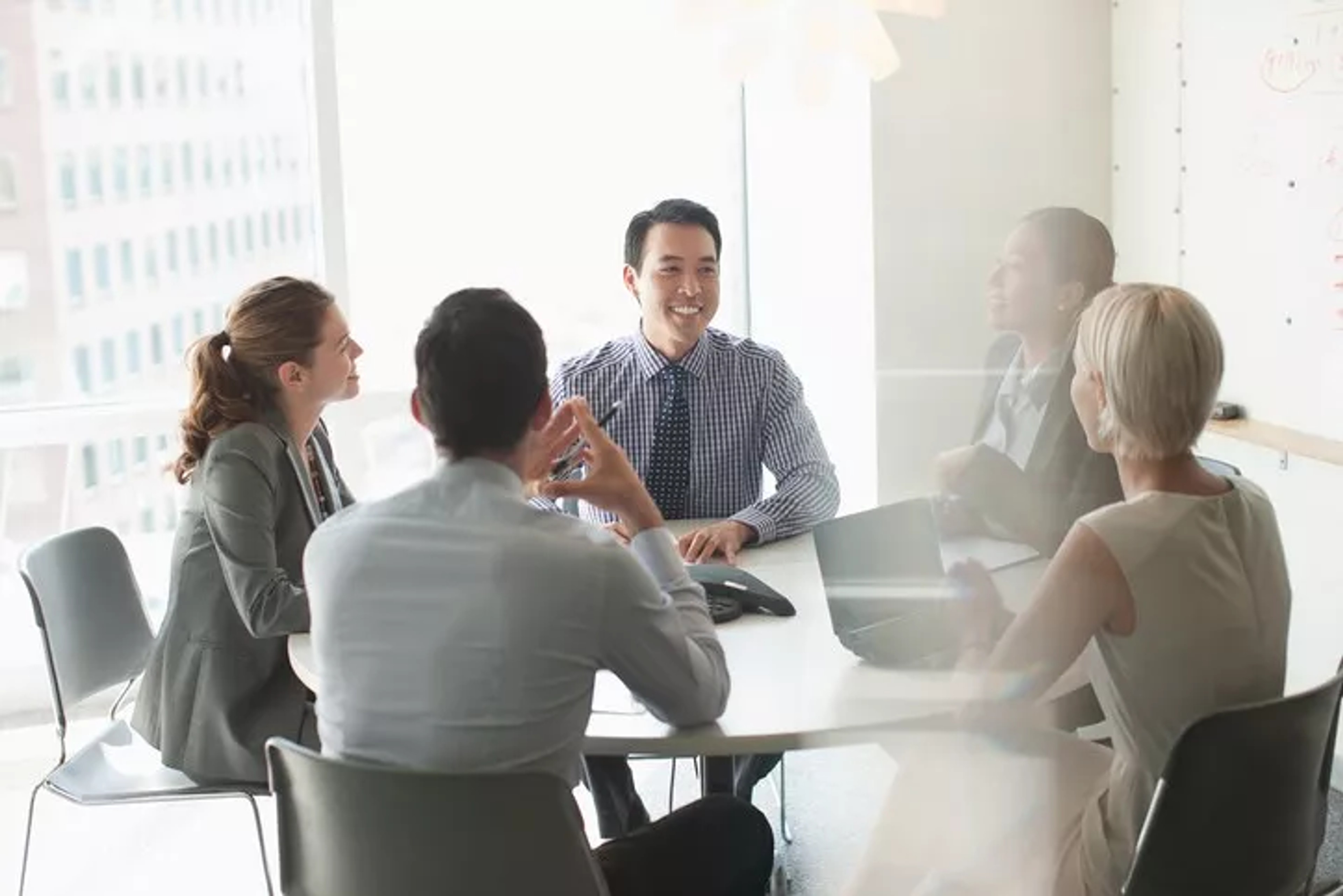 People sat around table illustrating being part of a holding company