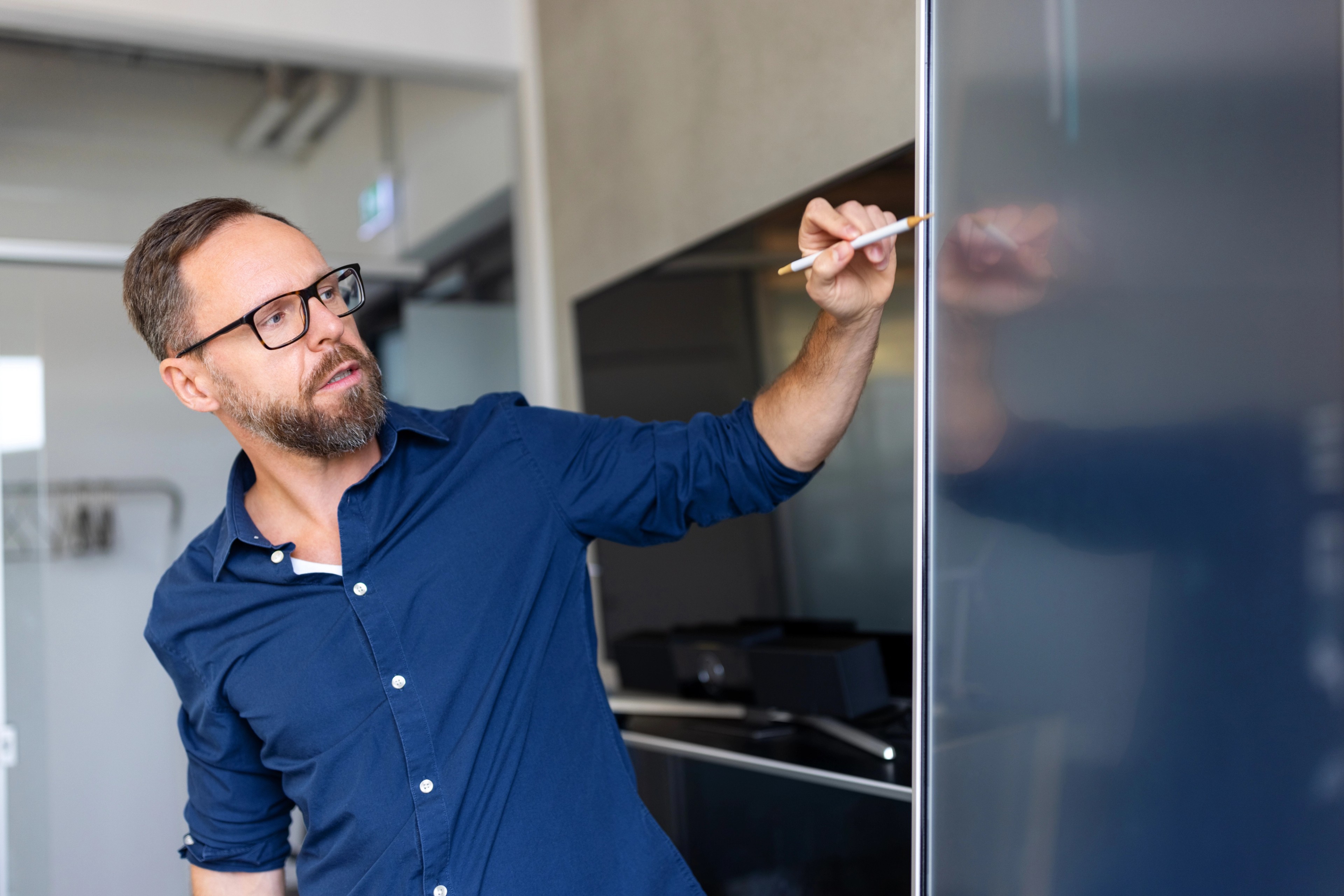 Entrepreprenur giving presentation on interactive screen in meeting room