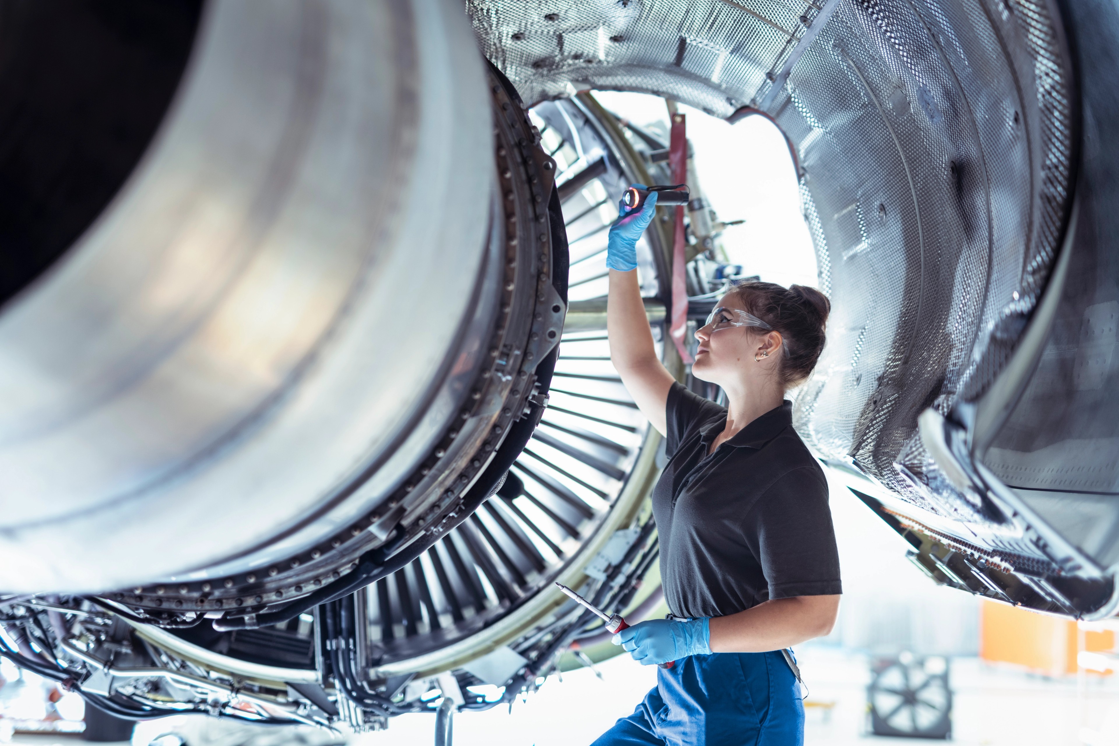 female engineer looks at airplane engine